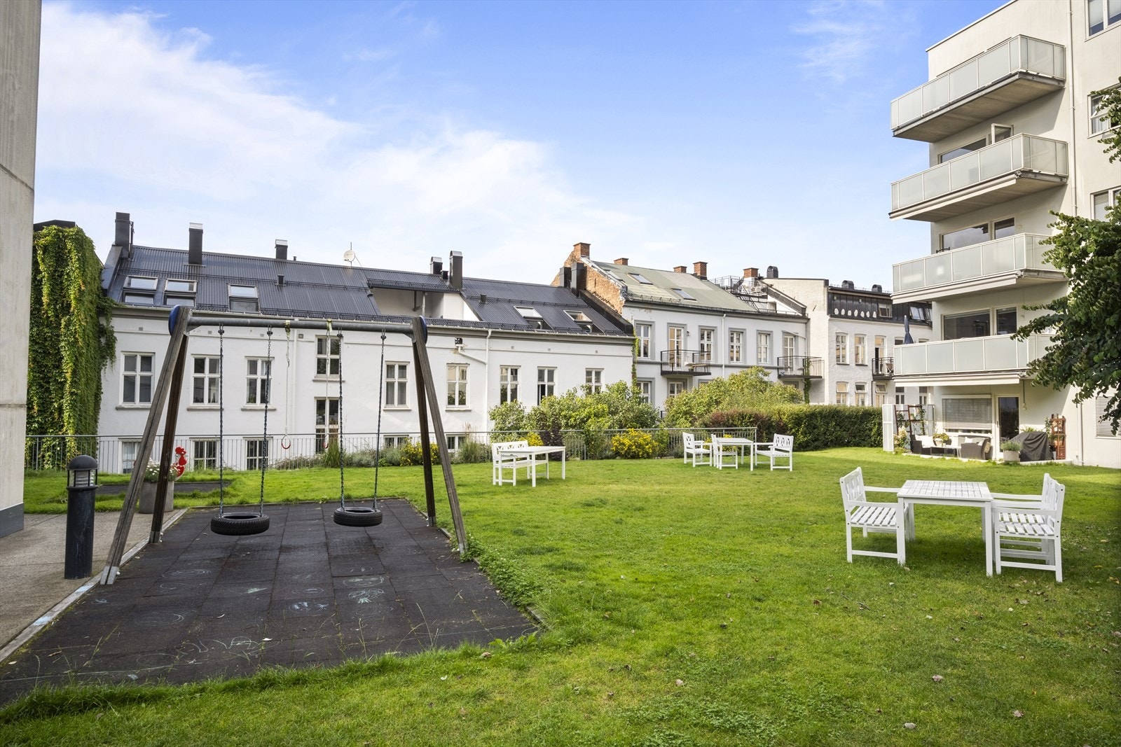 Skjermet gårdsrom pent opparbeidet med plen og beplantning Galleribilde