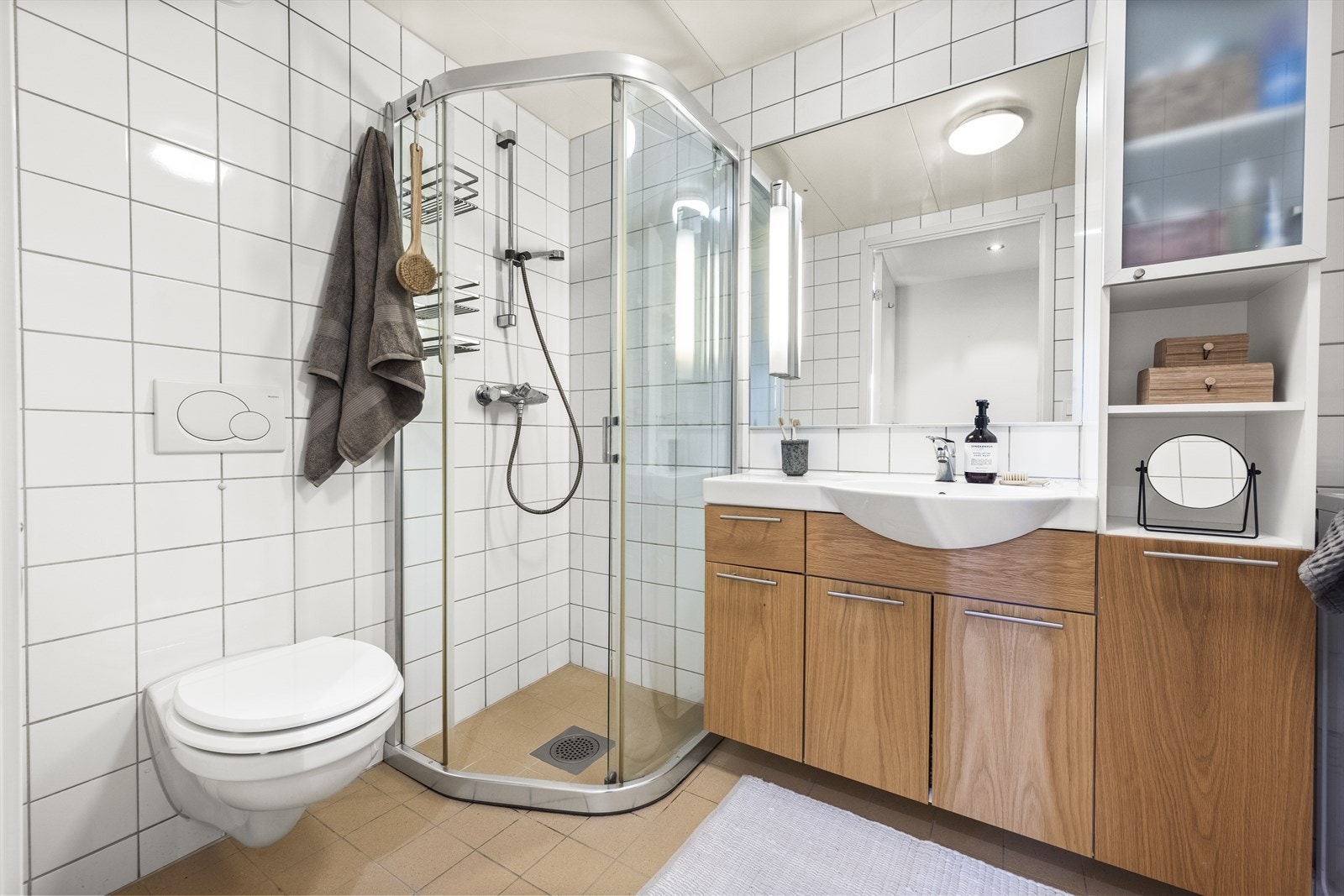 Innredet med vegghengt toalett, dusjhjørne og baderomsinnredning med servant nedfelt i innredning og speil m/lys Galleribilde