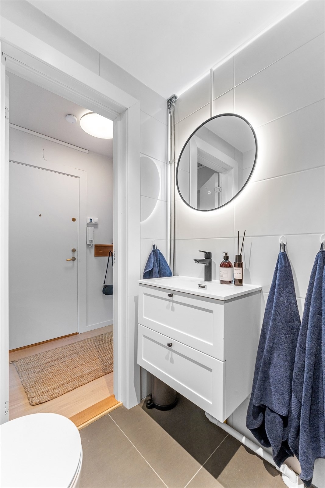 Badet er utstyrt med regnfallsdusj og foldedører i sorte detaljer, vegghengt toalett og servantinnredning. Det er opplegg og plass til vaskesøyle Galleribilde