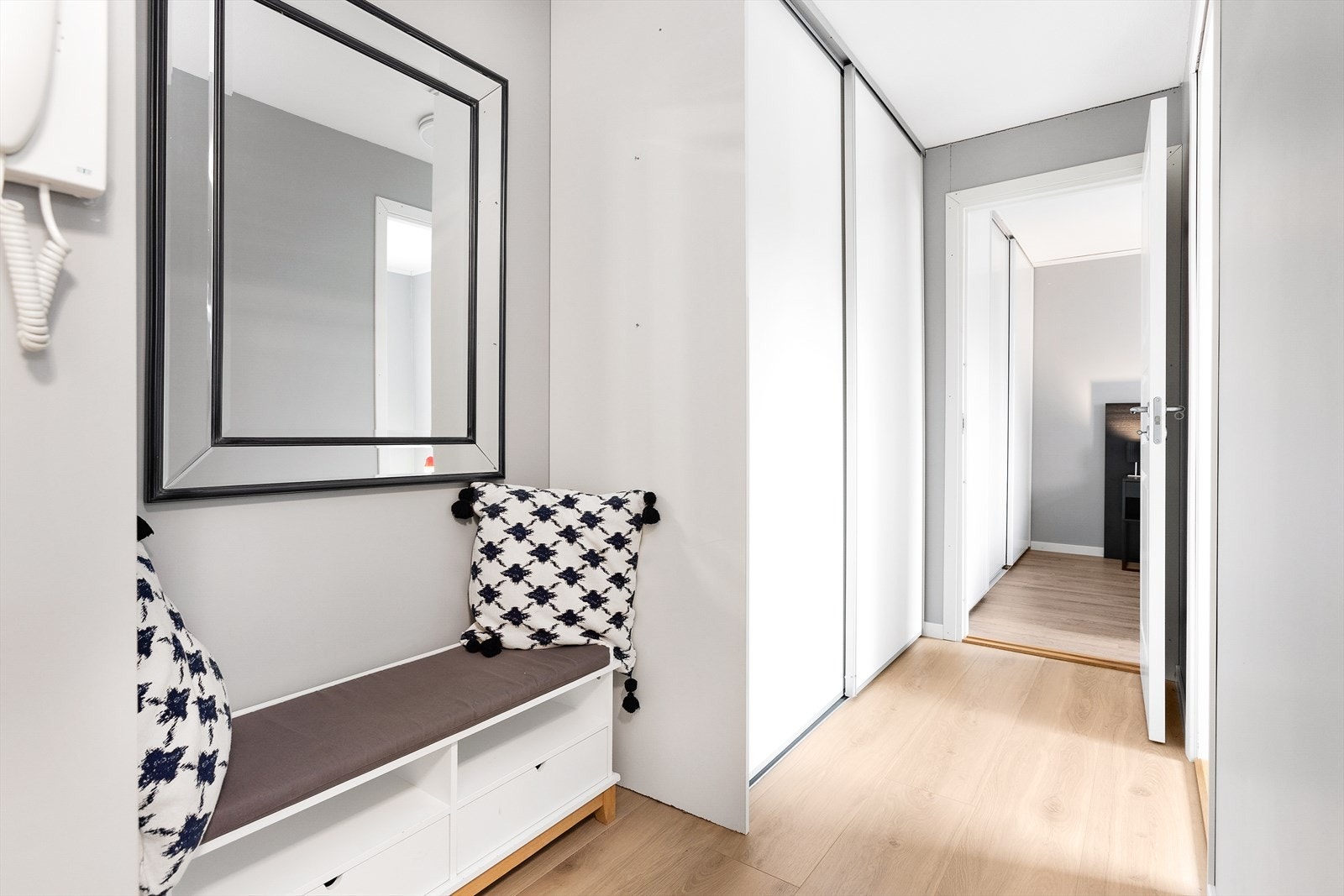 Velkommen inn til en lys og romslig entré. Fra entréen har du godt med oppbevaringsplass i en praktisk skyvedørsgarderobe. Galleribilde