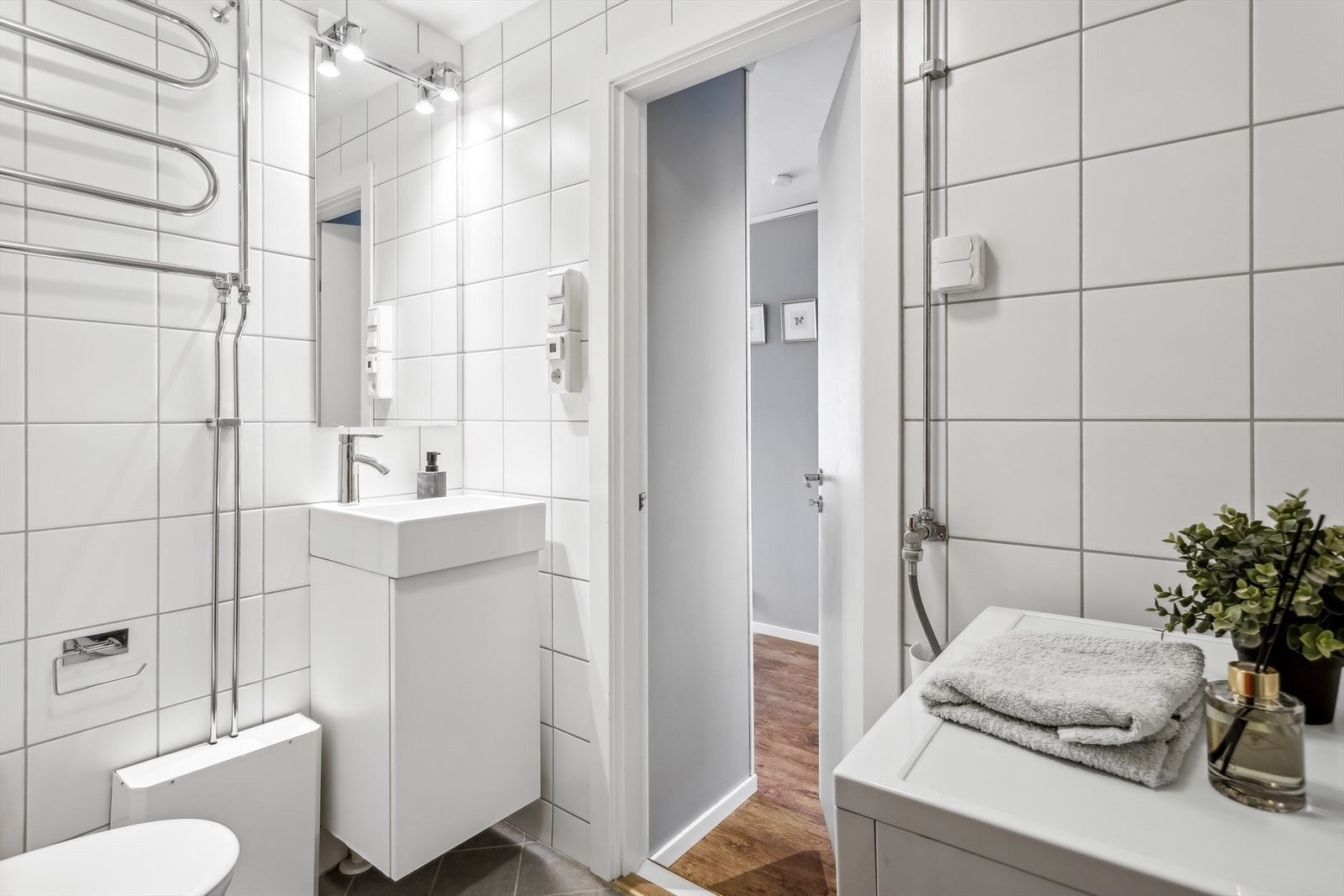 Flislagt baderom med varmekabler i gulvet og opplegg for vaskemaskin. Det er håndklevarmer på vegg. Badet ble pusset opp i regi av borettslaget i 2012. Galleribilde