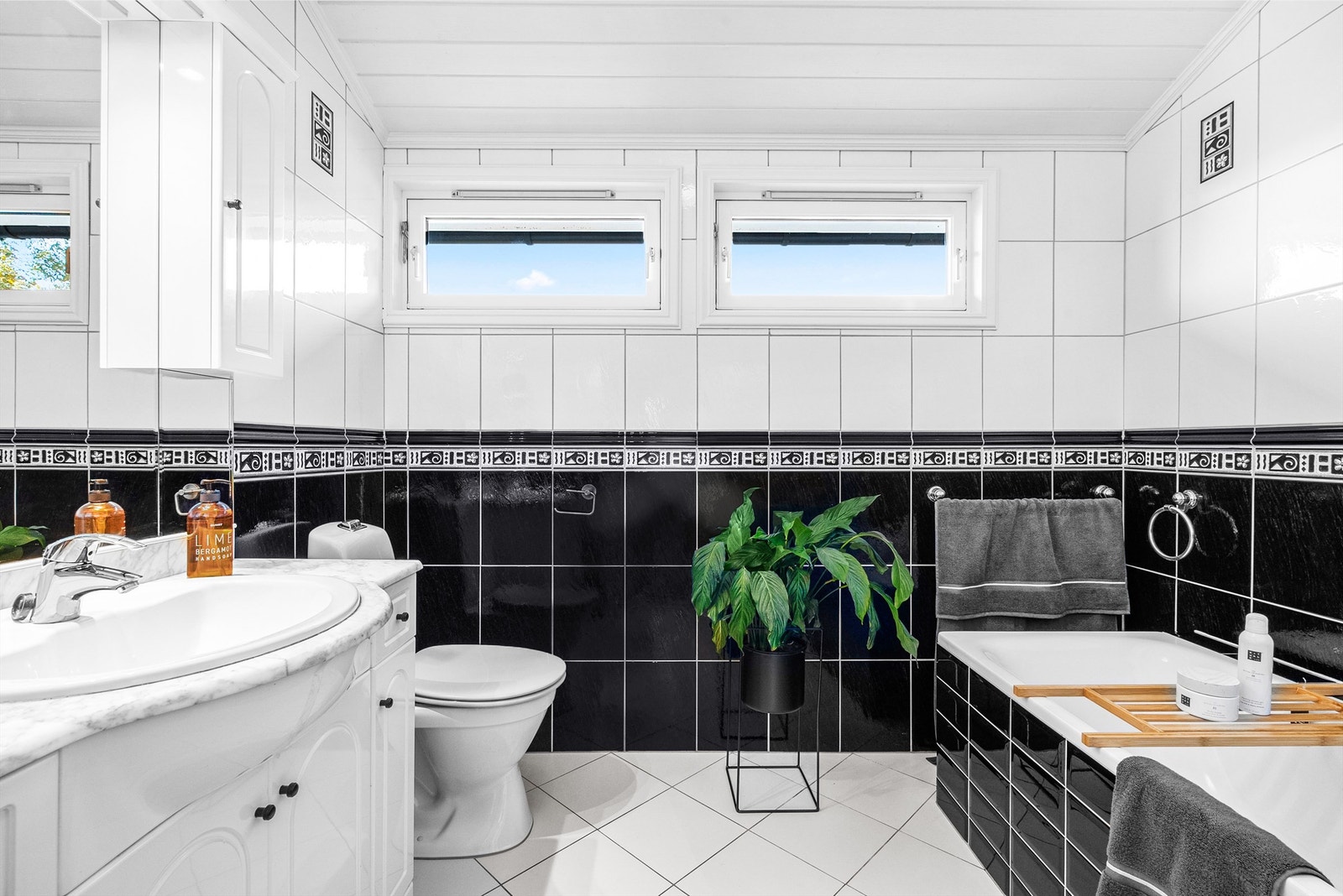 Badet er innredet med servant på innredning, klosett og dusjhjørne med faste vegger. Galleribilde