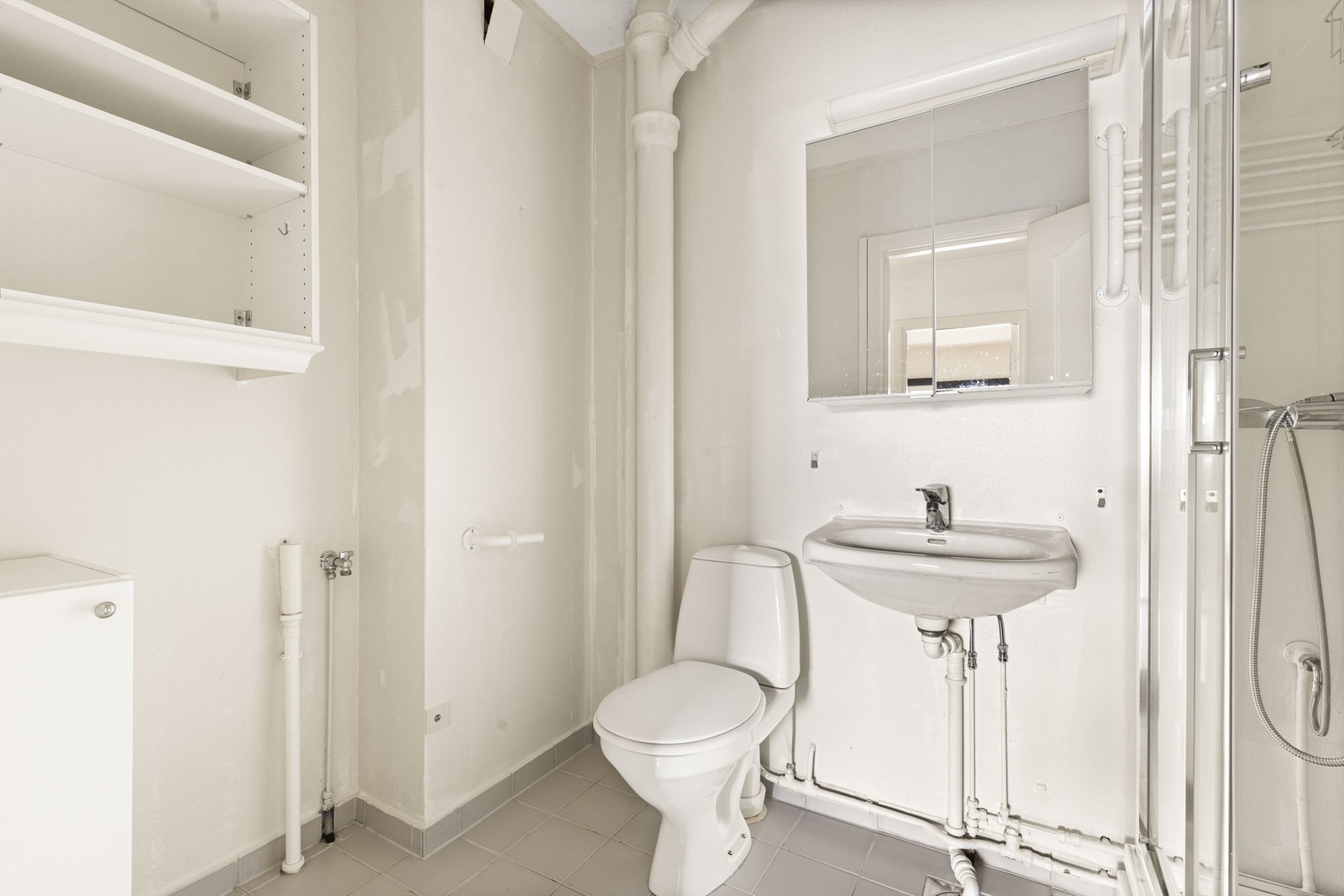 Eldre bad. Dusjkabinett og opplegg for vaskemaskin. Galleribilde