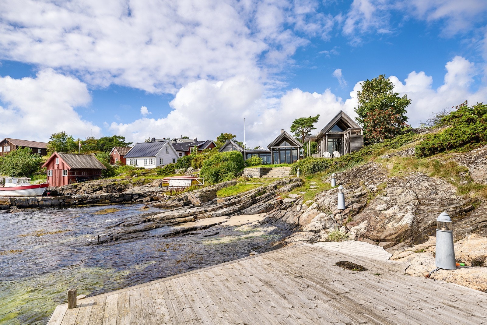 Eiendommen er omkranset av svaberg, terrasse og en hyggelig grønn plen som gir muligheter for både avslapning og aktiviteter for store og små Galleribilde