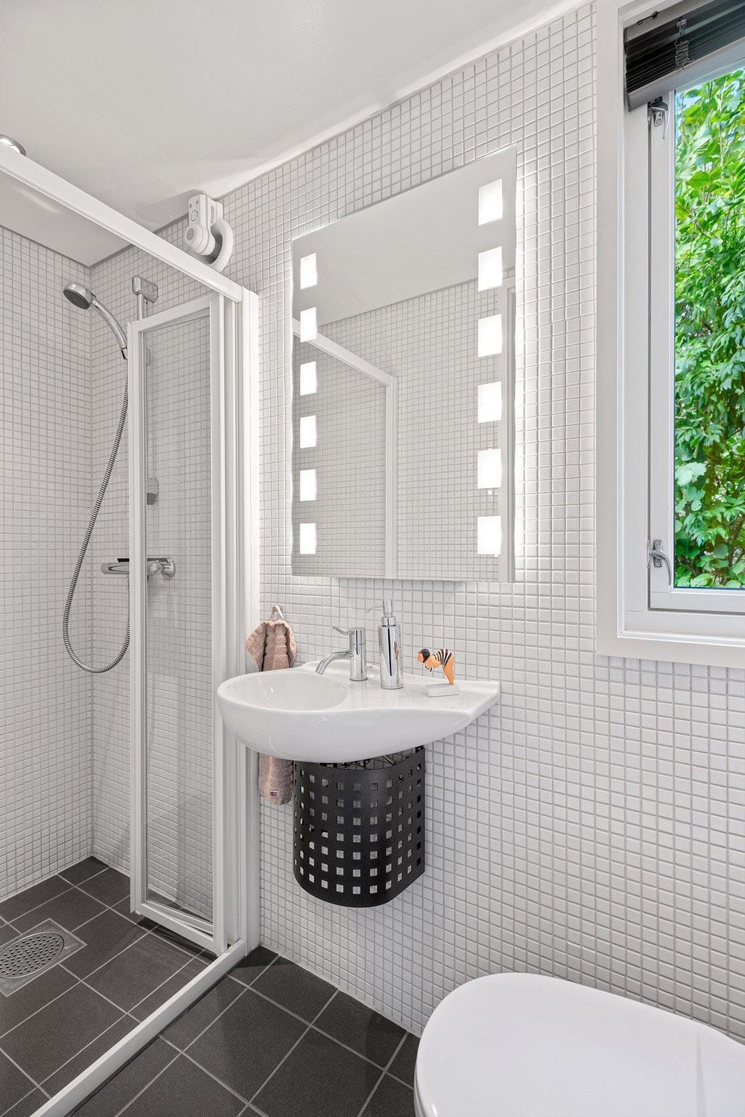 Flislagt bad med varmekabler i gulv. Innredet med toalett, baderomsvask og dusjgarnityr Galleribilde