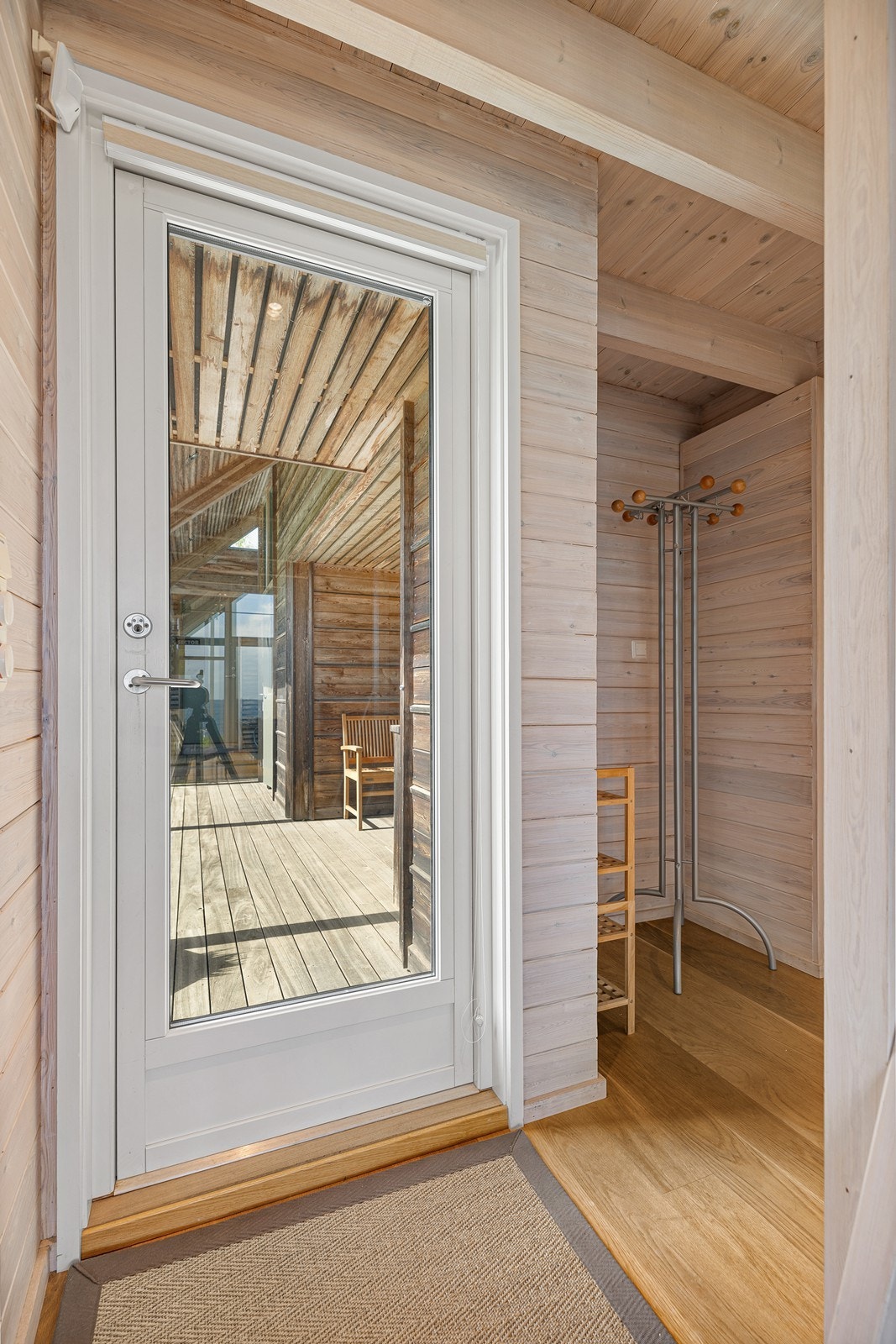 Lys gang med pent 1-stavs eikeparkett på gulv og trepanel på vegger. God plass til oppbevaring av yttertøy og sko Galleribilde