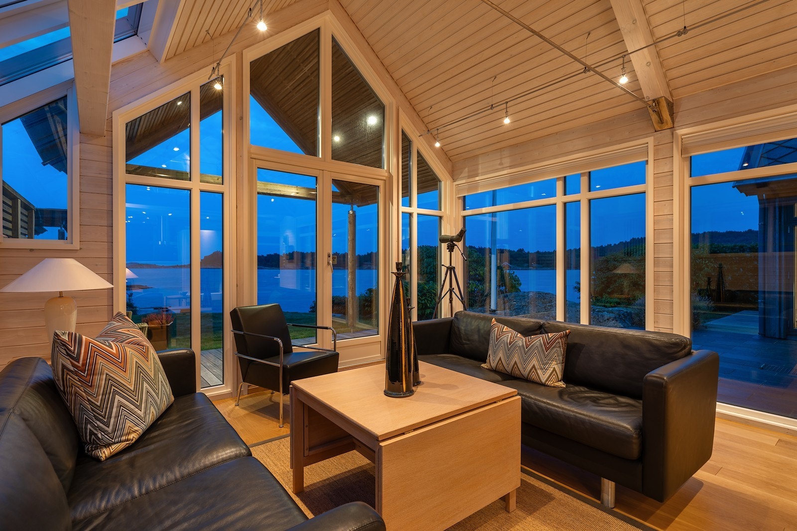 Stuen har flere vindusflater som strekker seg helt opp til taket og slipper inn godt med naturlig lys Galleribilde