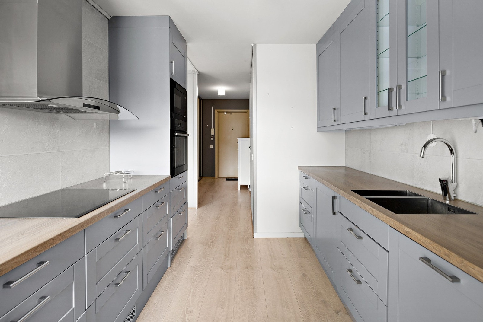 Alt av integrerte hvitevarer medfølger handelen. Legg merke til praktisk plassering av både komfyr og mikrobølgeovn i ståhøyde. Galleribilde