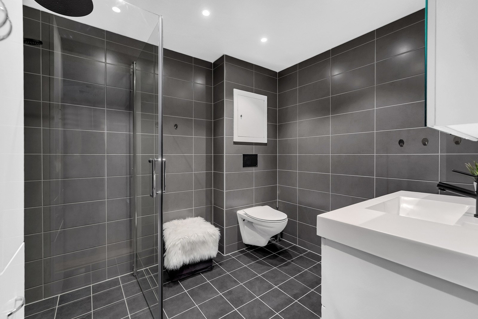 Badet er lekkert, og har fliser på gulv og vegger. Det er varme i gulv og spotter i himling. Våtrommene i leiligheten ble rehabilitert i regi av borettslaget i 2021. Galleribilde