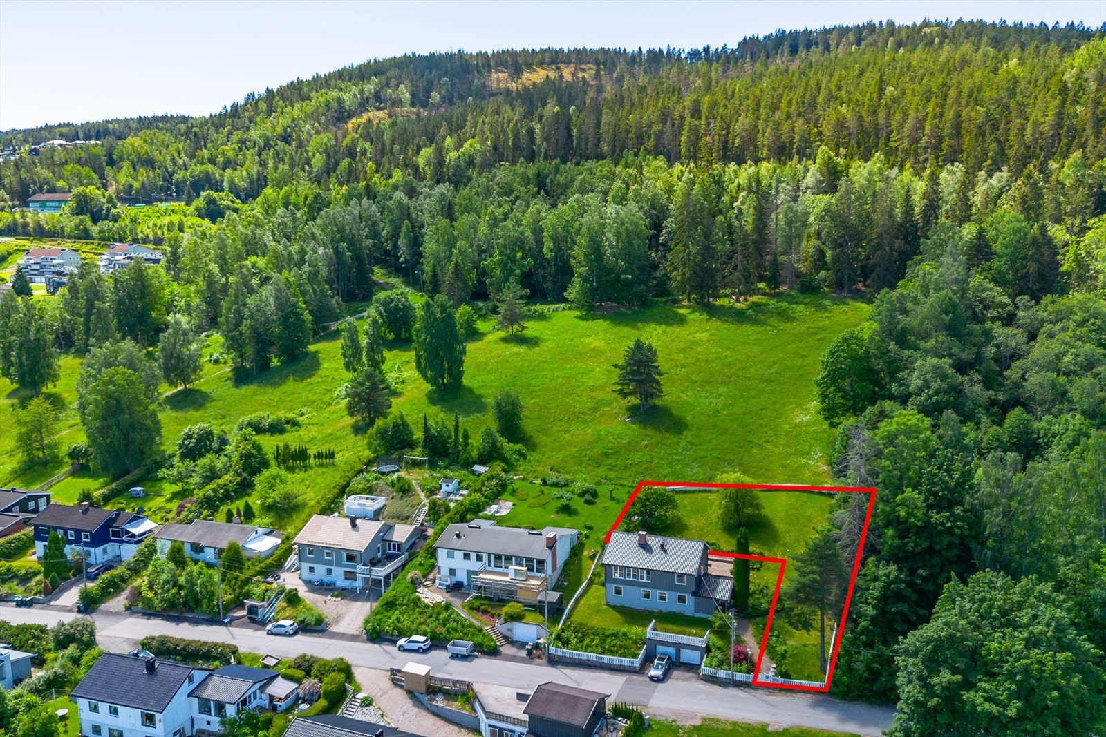 Austadjordet med grønn og fin eng ligger i bakkant av tomten Galleribilde