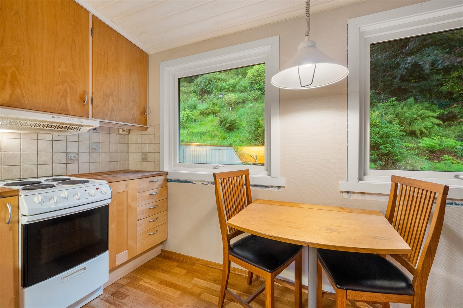 Kjøkkenet har innredning med profilerte fronter og heltre benkeplate. Over benkeplaten er det benyttet fliser, stål oppvaskkum, ventilator. Galleribilde