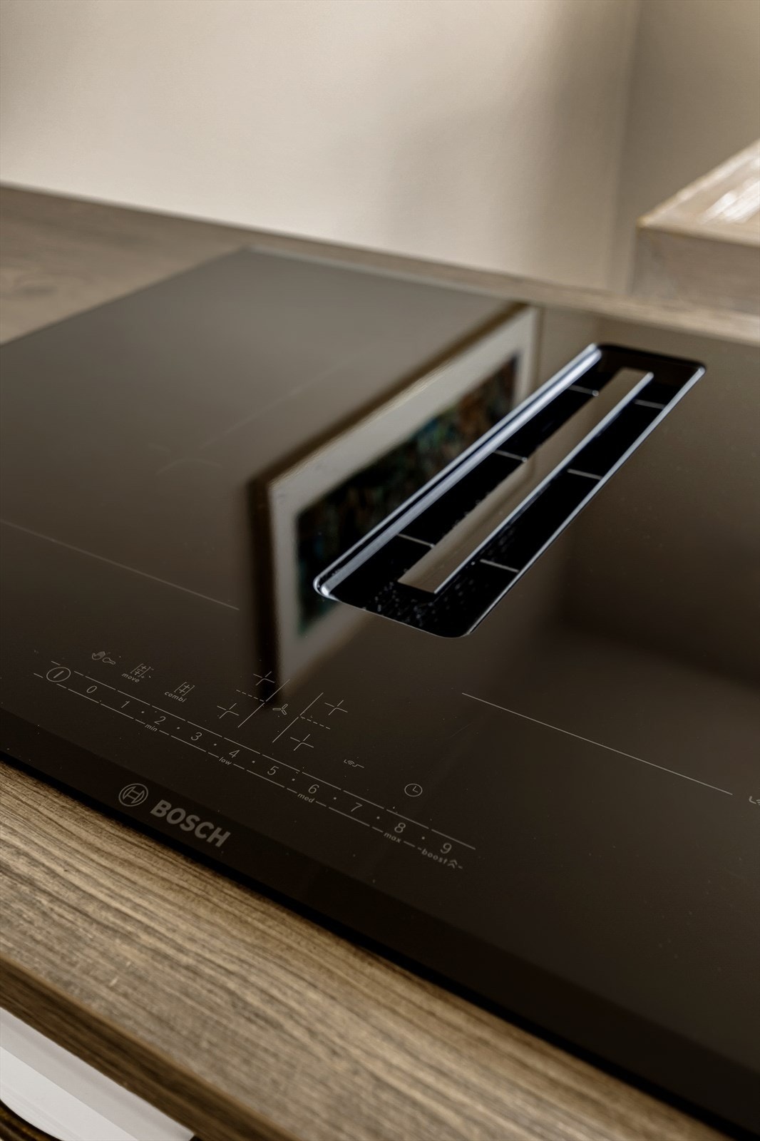 En nedfelt platetopp med integrert avtrekk i kjøkkenhalvøya sørger for en sømløs og moderne arbeidsflate. Galleribilde