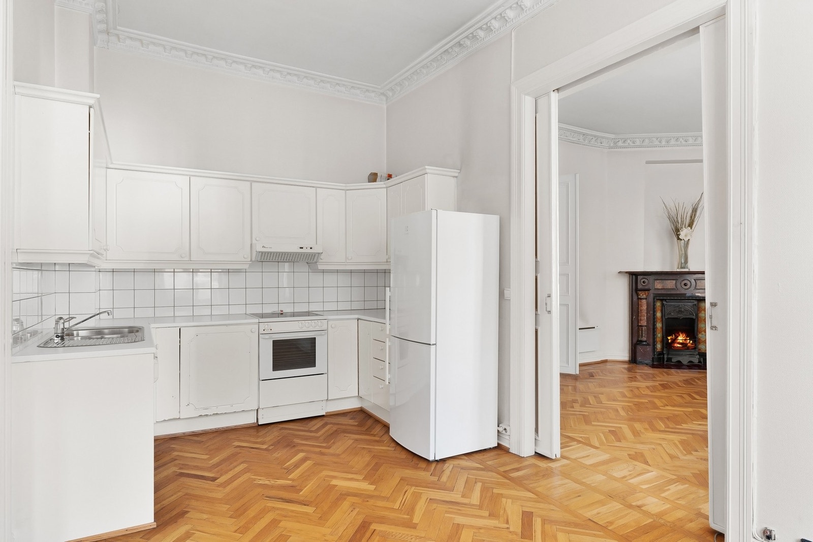 Kjøkkenet ligger vegg i vegg med stuen og skilles av med nostalgiske skyvedører. Galleribilde