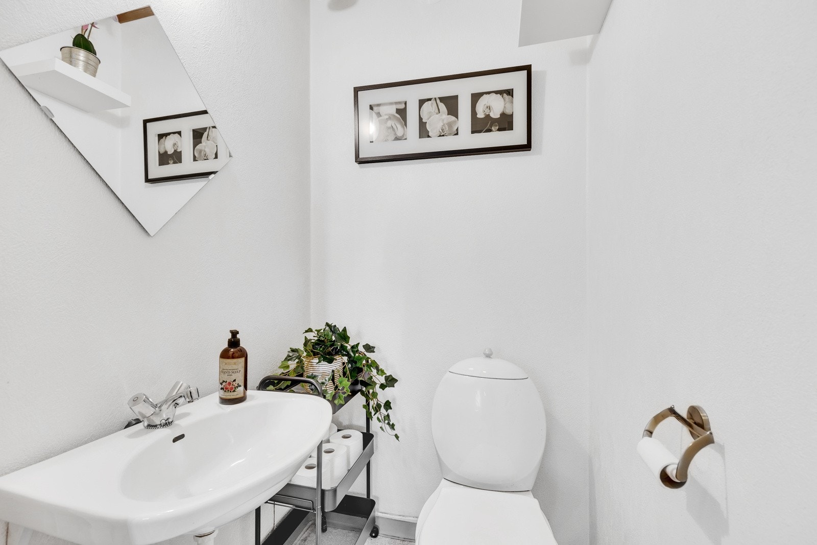 Leiliheten har et praktisk toalettrom med toalett og vegghengt servant. Galleribilde