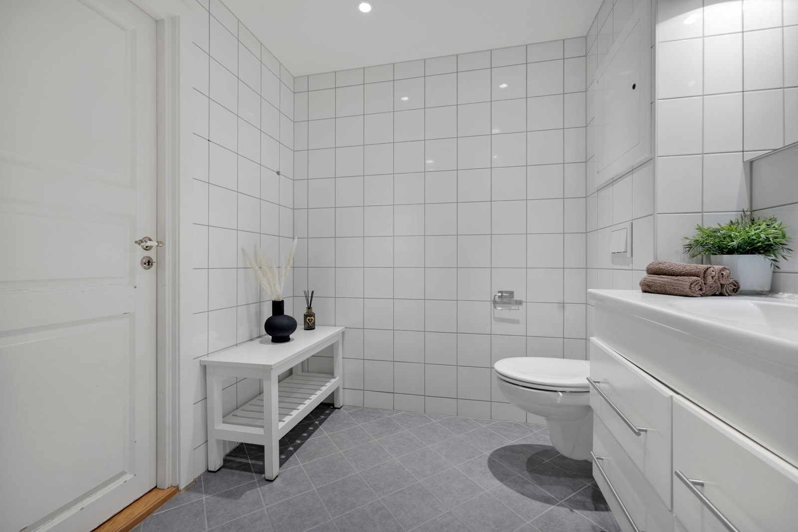 Det romslige badet er flislagt med gulvvarme og downlights i himlingen Galleribilde