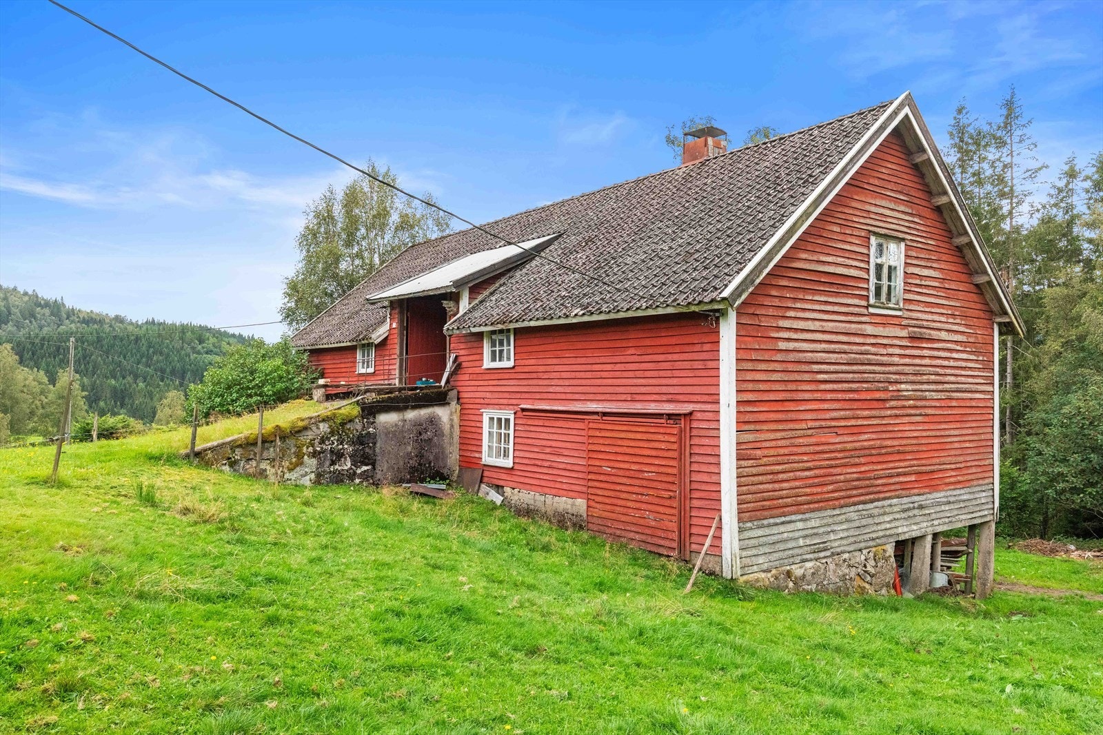 Fjøs/låve fra 1936. Større skader på kledning på ene langsiden som må beregnes å bordkles på nytt. Taktekkingen av betongstein er slitt. Eldre vinduer med noen knuste glass. Ene endeveggen med gavlvegg er blitt kledd på nytt. Galleribilde