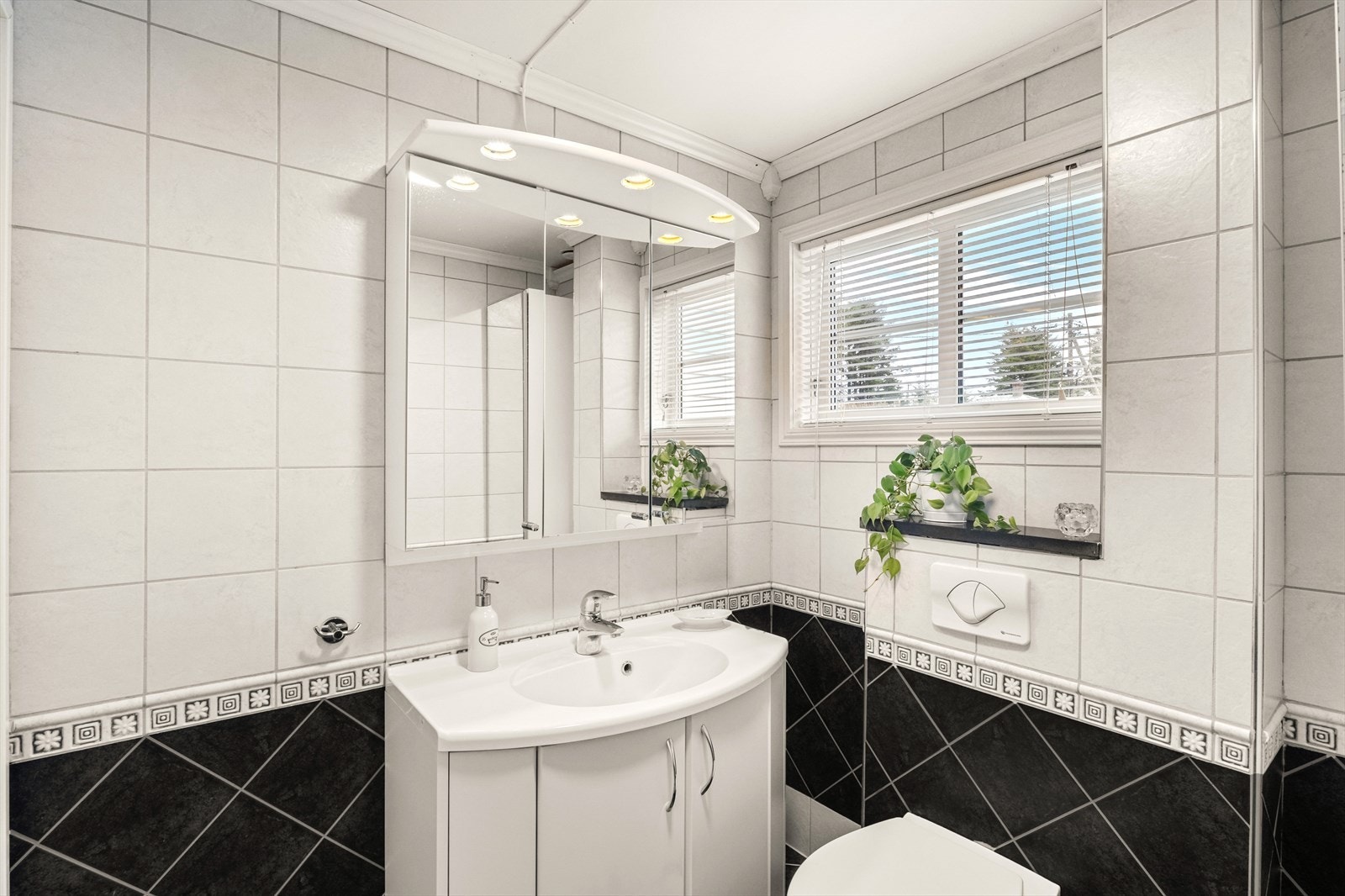 Bad nr. 2 har flislagte overflater og inneholder vegghengt toalett, baderomsmøblement med servant og dusjhjørne. Galleribilde