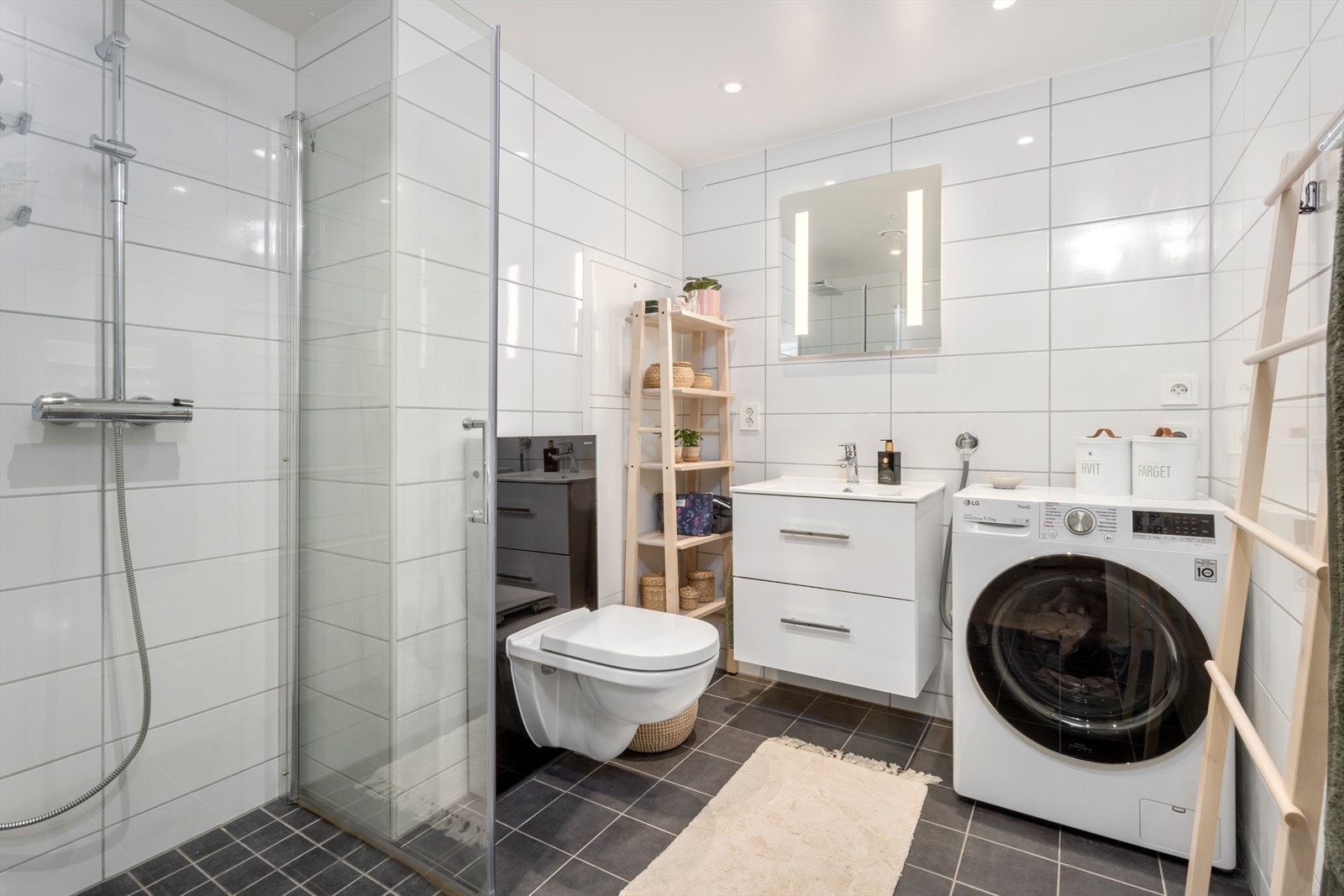 Badet er pent utført med hvite fliser på veggene og grå fliser på gulvet, der det også er behagelig gulvvarme. Galleribilde