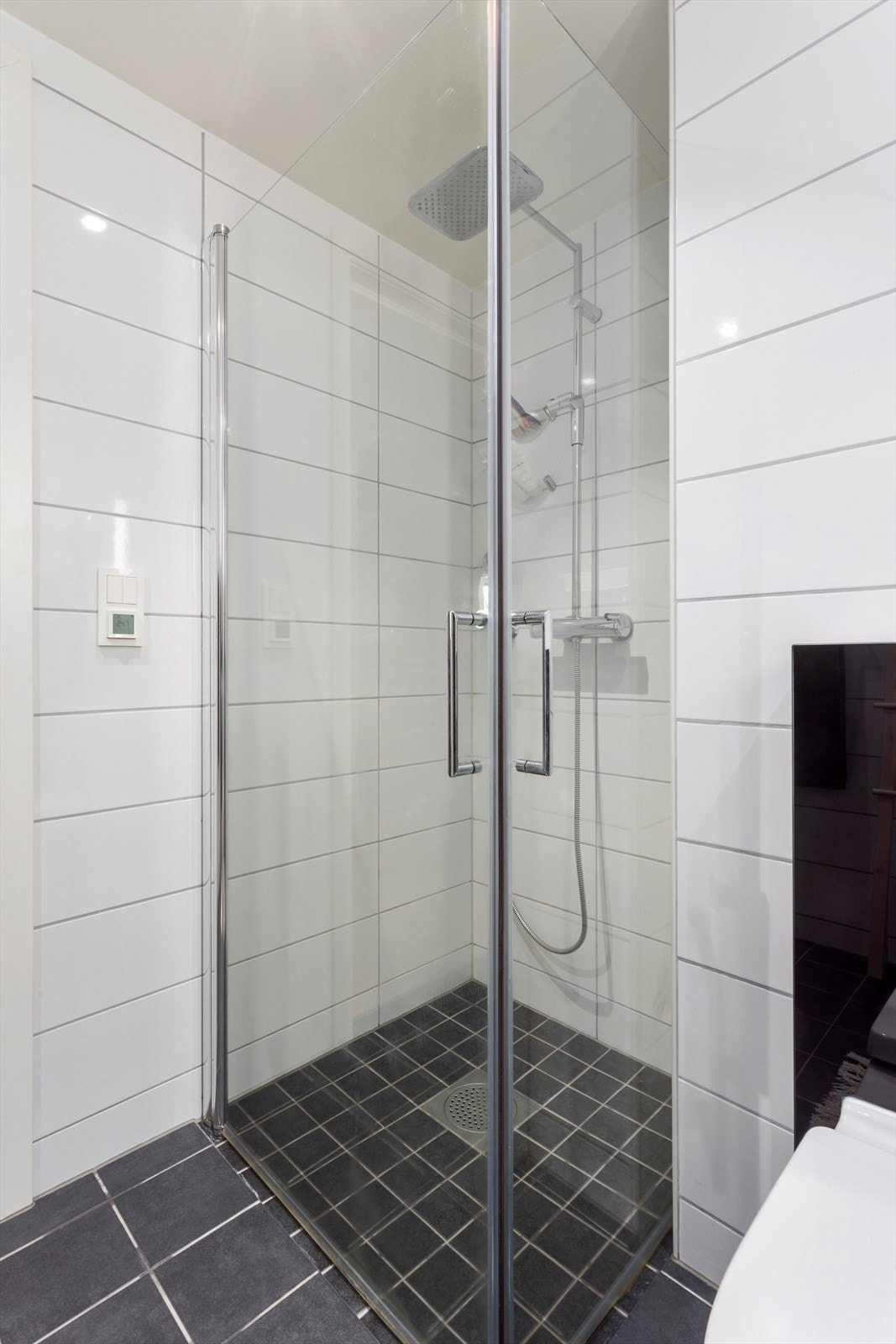 Badet er tidsriktig utstyrt med dusjhjørne, innredning med nedfelt servant, veggmontert toalett og opplegg for vaskemaskin. Galleribilde