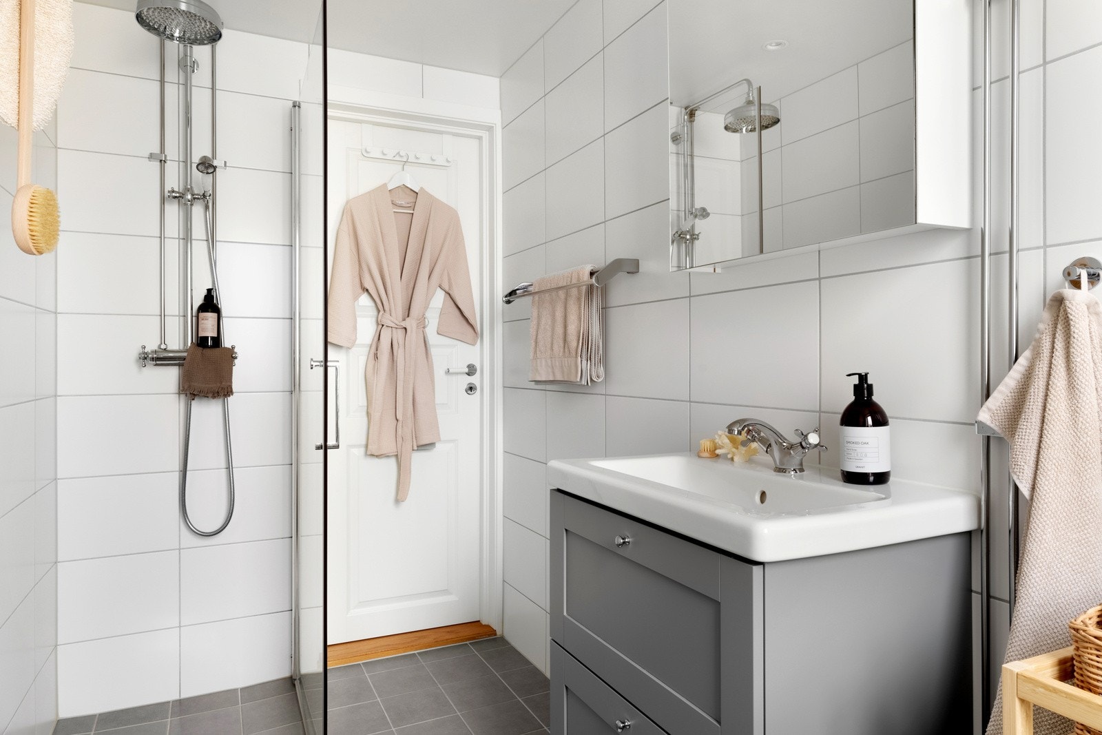 Badet er innredet med vegghengt toalett, opplegg for vaskemaskin, baderomsinnredning, samt dusjhjørne med glassvegger og regnfallsdusj. Galleribilde