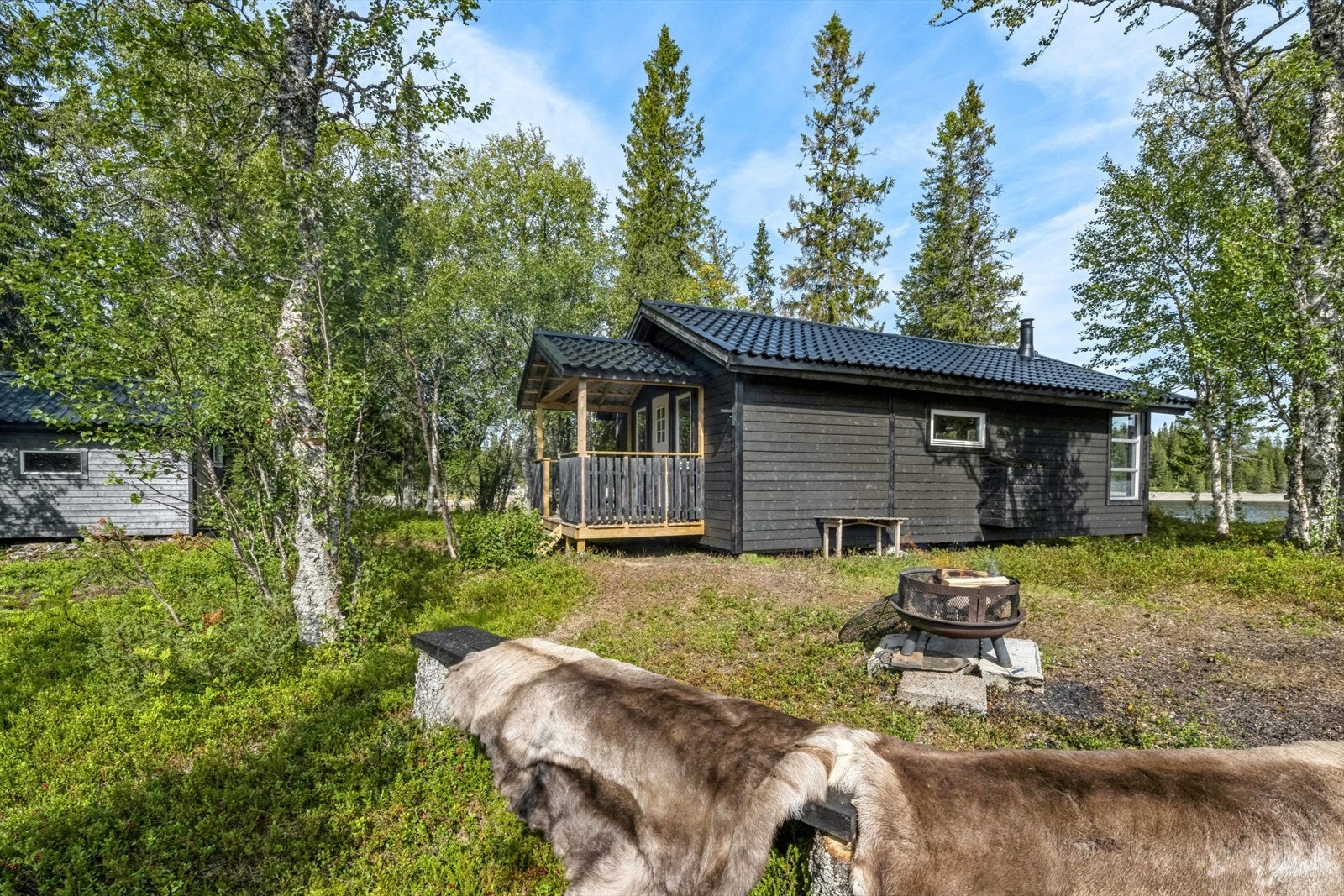 Hytta er omkranset av vann og et variert landskap, dominert av lyng og annen naturlig vegetasjon, noe som skaper en fredelig og idyllisk atmosfære. Galleribilde