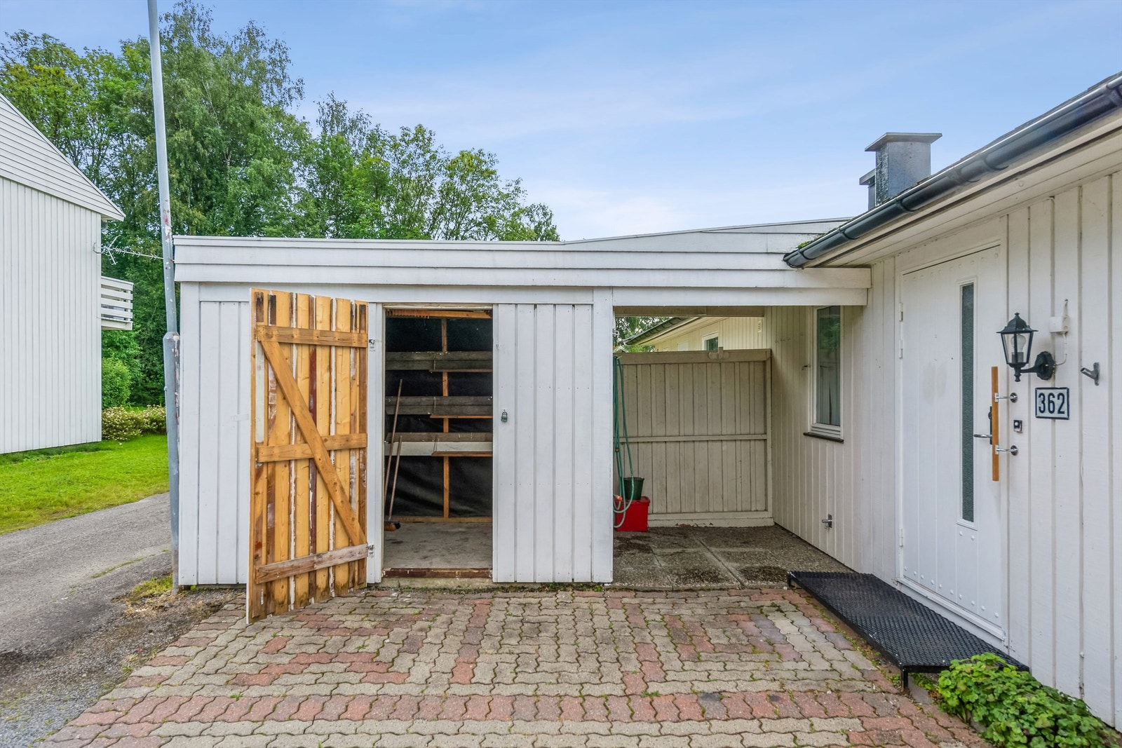 Romslig utvendig bod ved inngangspartiet. Lite overbygg - praktisk for parkering av sykler mm Galleribilde