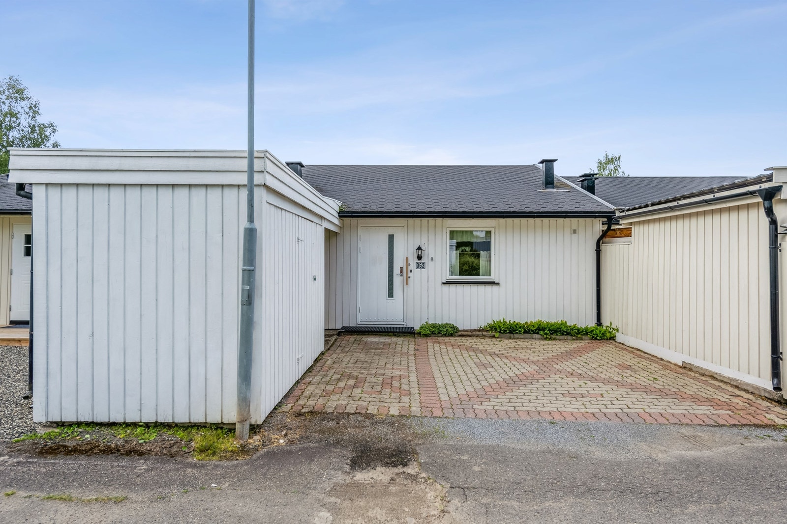 Gårdsplassen ved inngangspartiet har belegningsstein - ryddig og pent Galleribilde