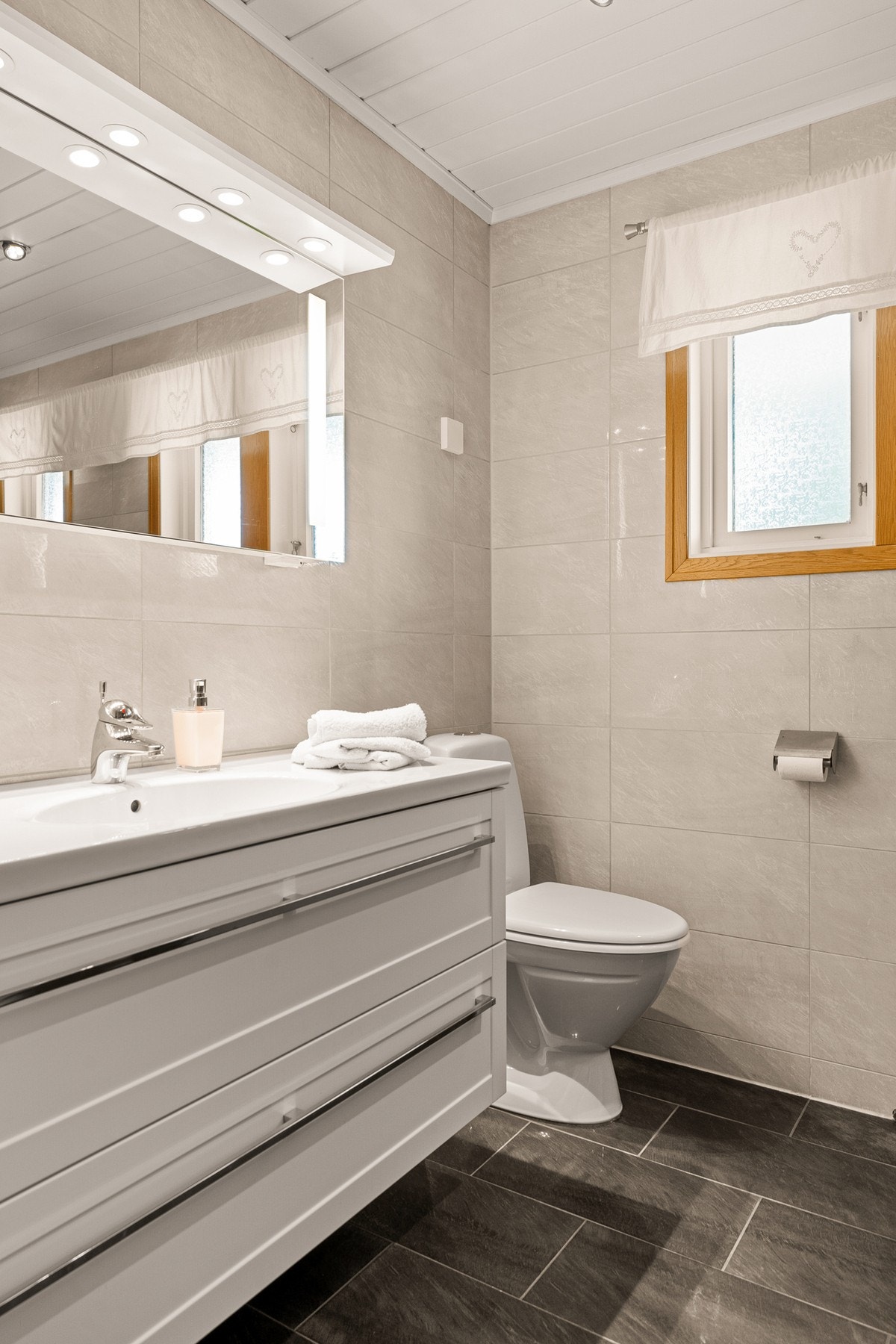 Badet har innredning/servant, toalett og dusjkabinett. Galleribilde