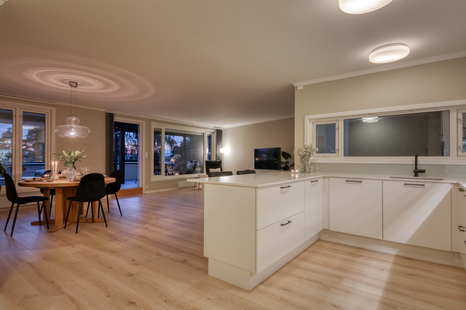 Leilighetens sosiale sone inkluderer stue, spisestue og kjøkken som er samlet i en moderne åpen løsning. Galleribilde