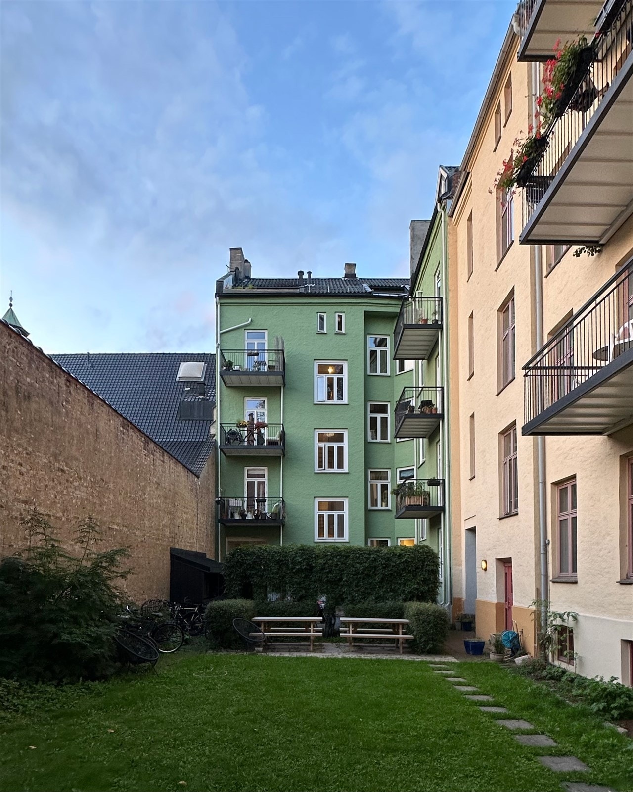Borettslagets bakgård er representativ og pent opparbeidet med gressplen, sittegrupper, sykkelparkering og beplantning. Galleribilde