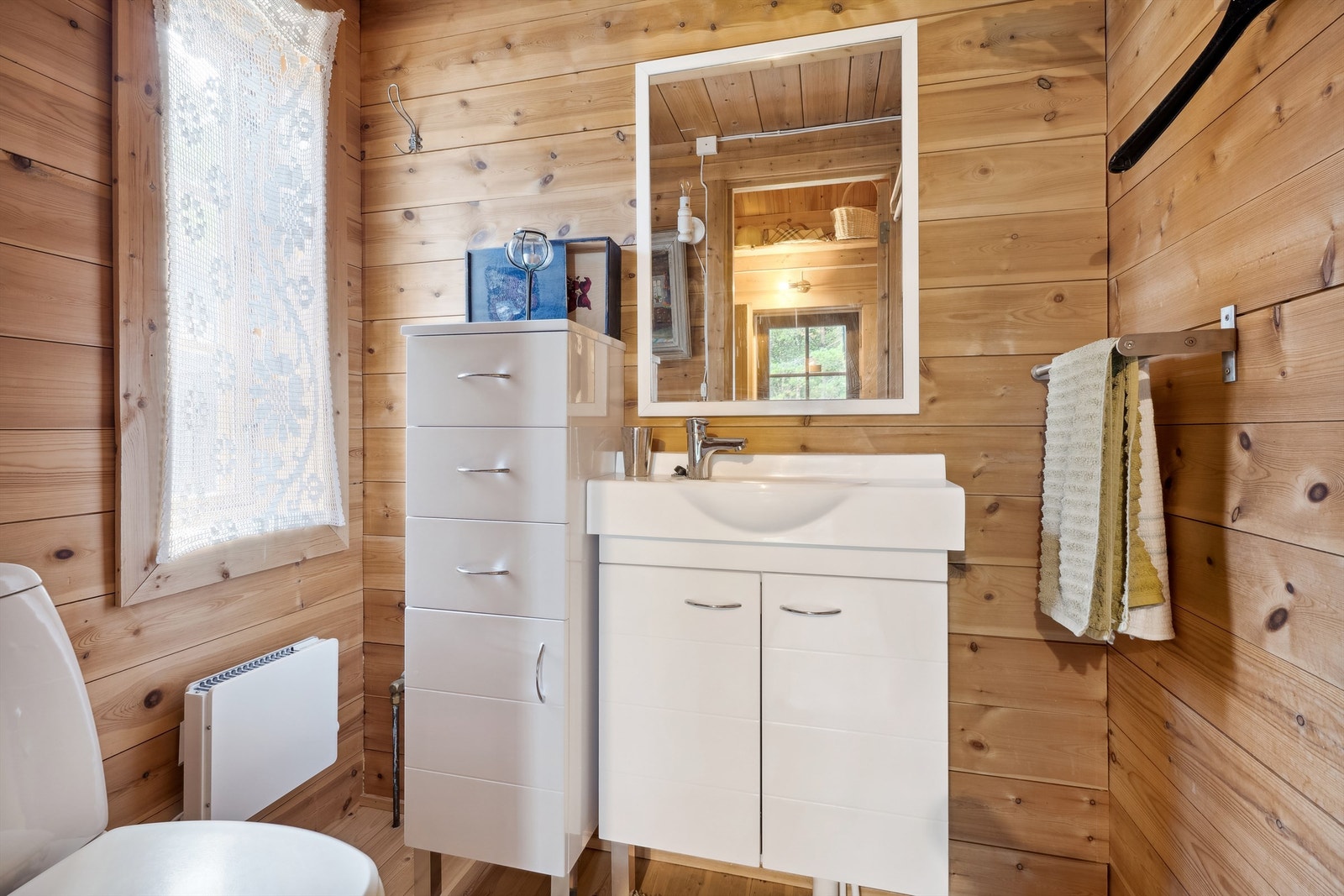 Separat toalettrom med skapinnredning - Det er panelovner i flere rom Galleribilde