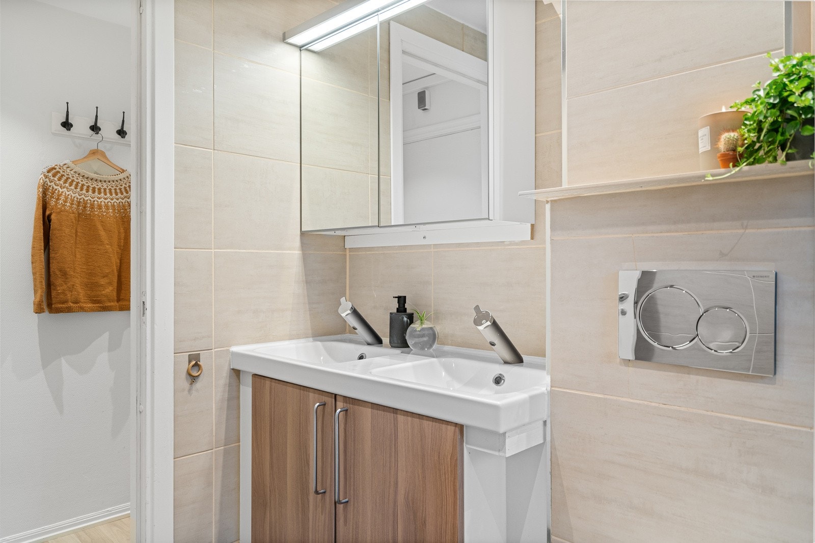 Romslig bad med vegghengt toalett, dusj og servantinnredning med speil. Galleribilde