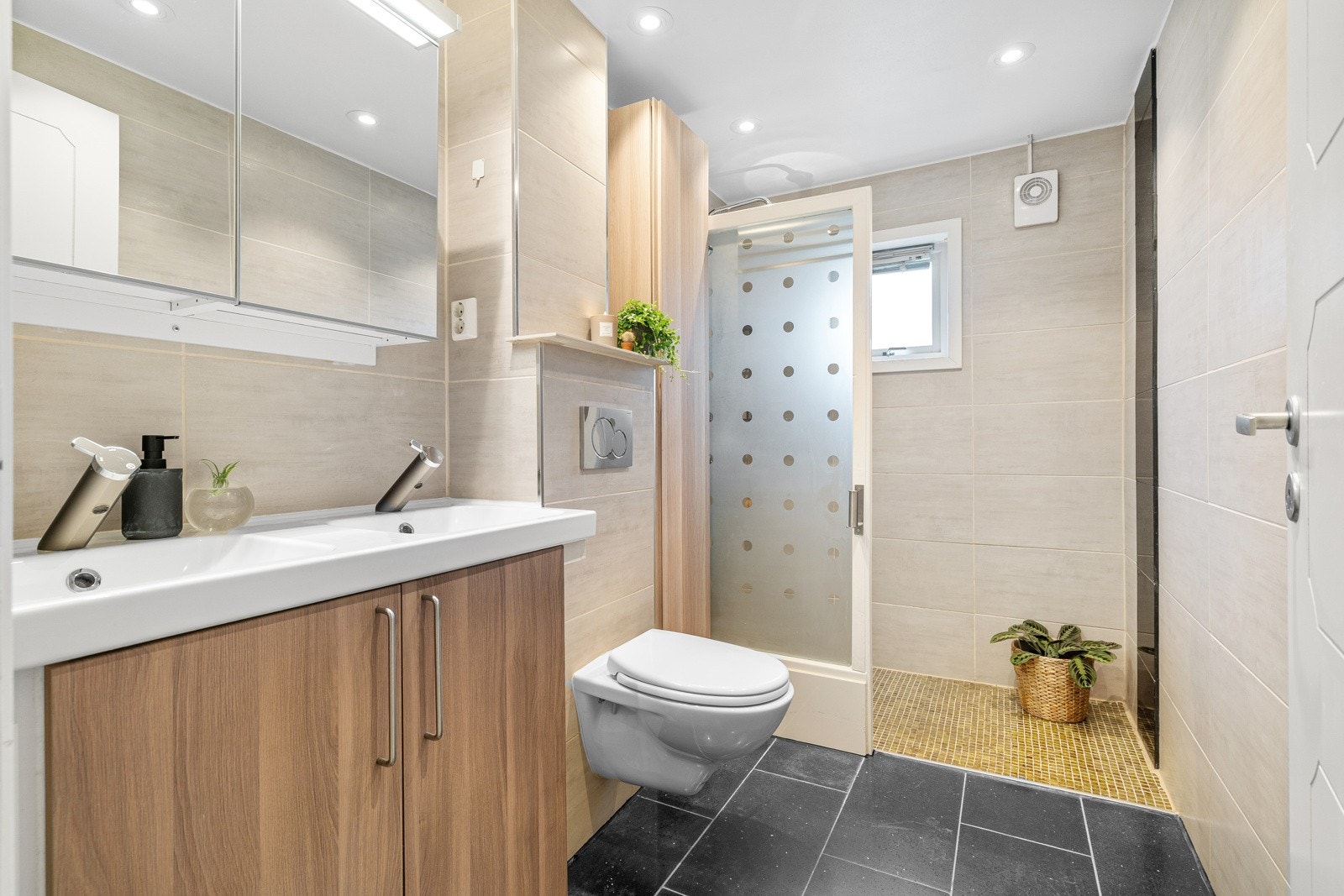 Bad i 1. etasje har flislagte vegger og gulv med gulvvarme. Galleribilde