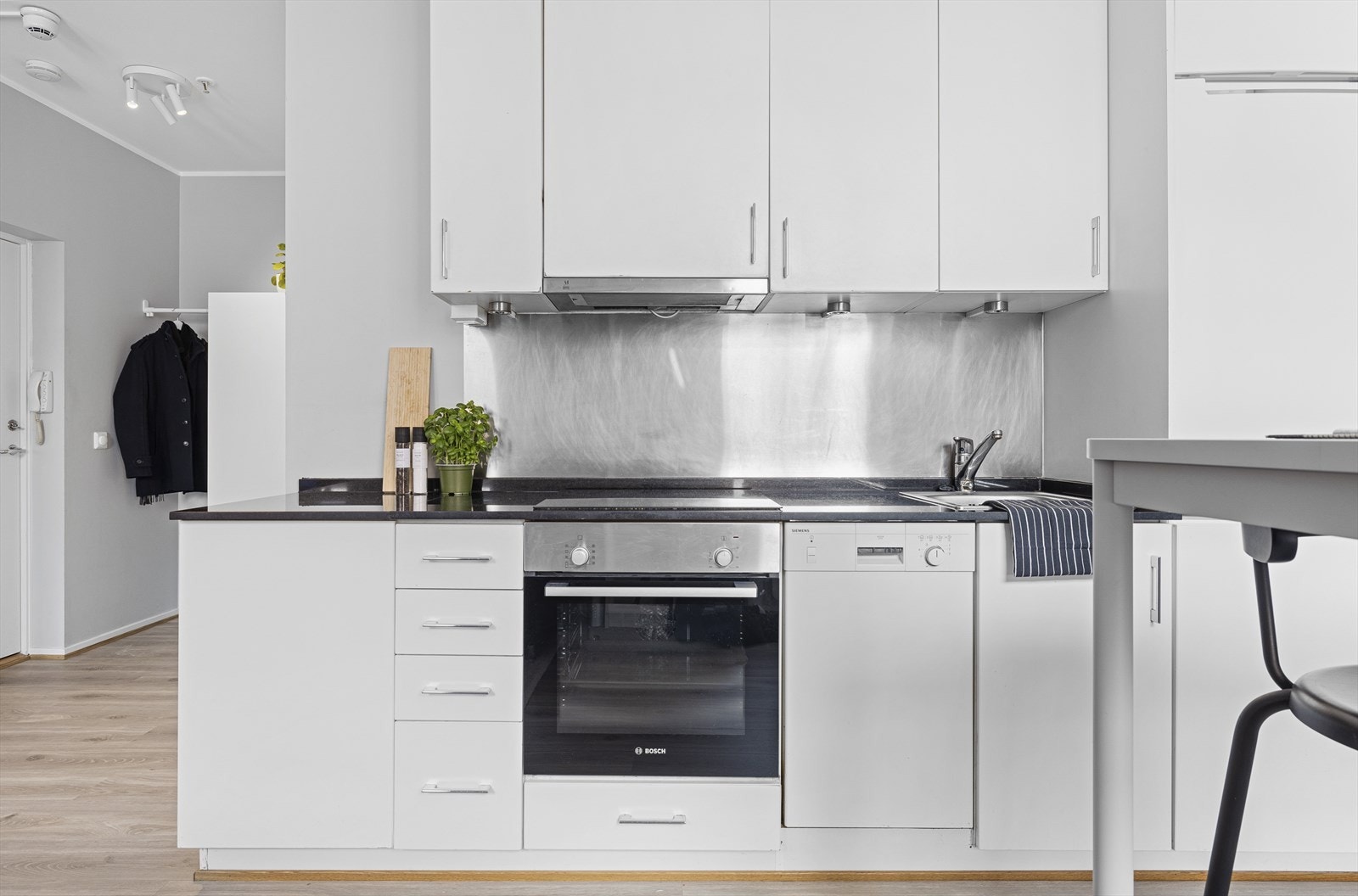 Tidløs kjøkkeninnredning som gir godt med skap- og benkplass. Kjøkkeninnredningen er fra 2006 med glatte, folierte fronter. Galleribilde