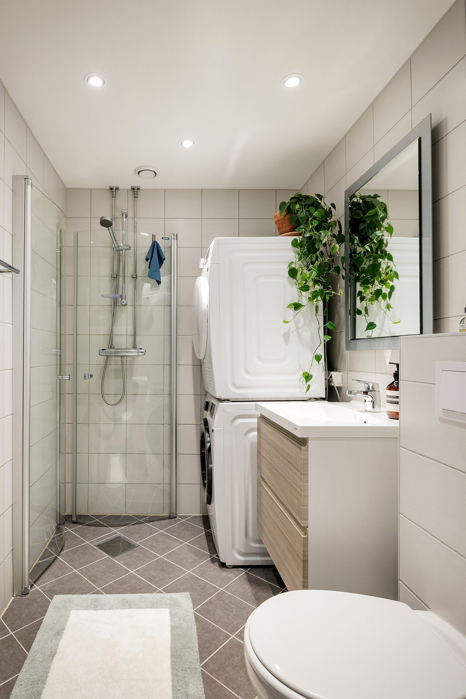 Badet har vegghengt toalett og innfellbare buede dusjvegger i glass Galleribilde