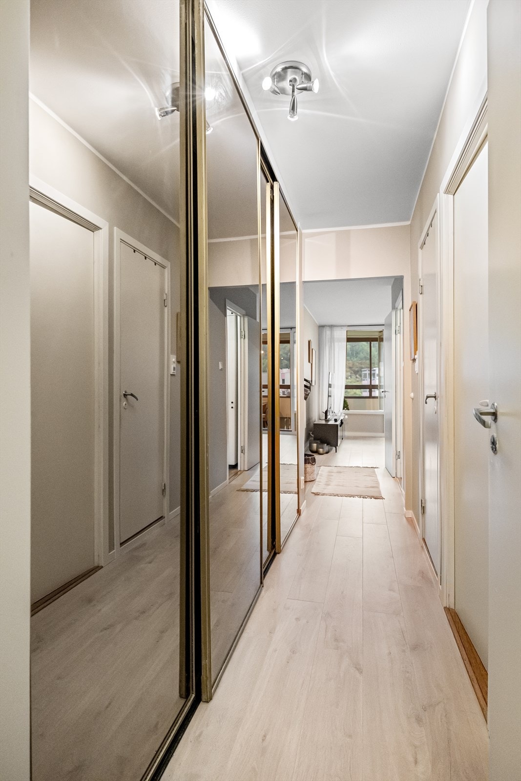 Romslig gang med stort innebygget garderobeskap og elegante skyvedører med glassfronter. Galleribilde