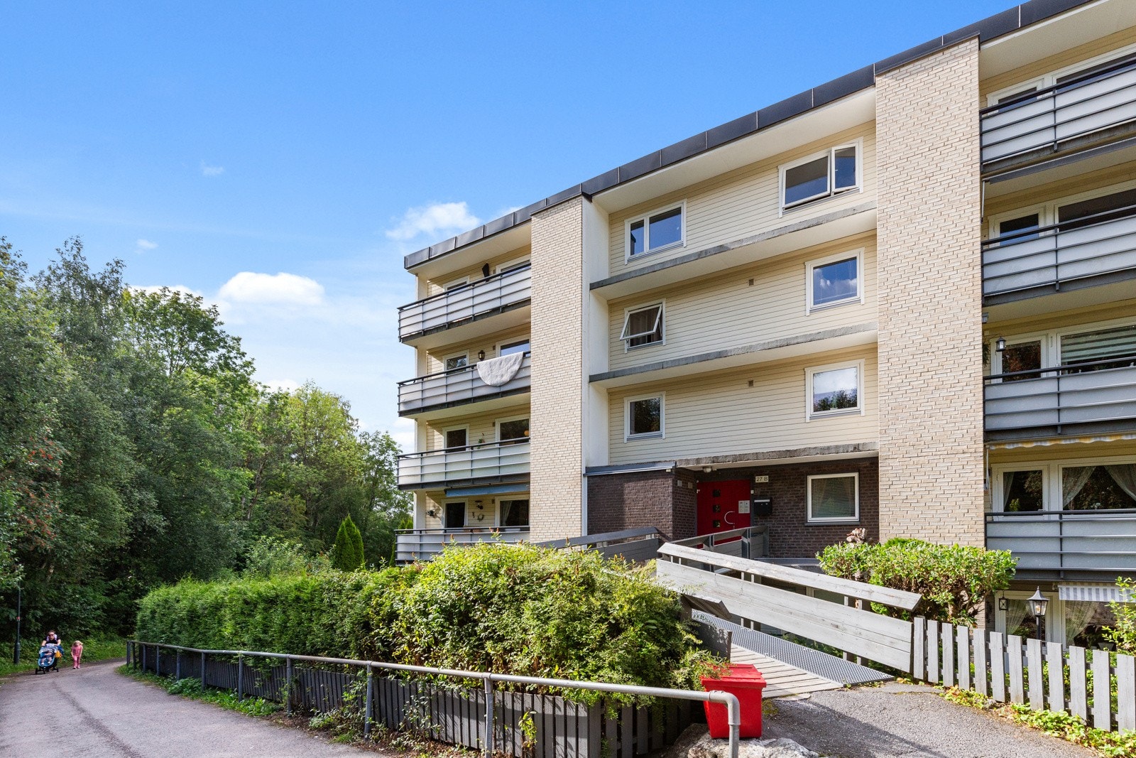 Fasade vist fra inngangspartiet hvor leiligheten ligger i 2. etasje, en trapp opp, og på enden av bygget Galleribilde
