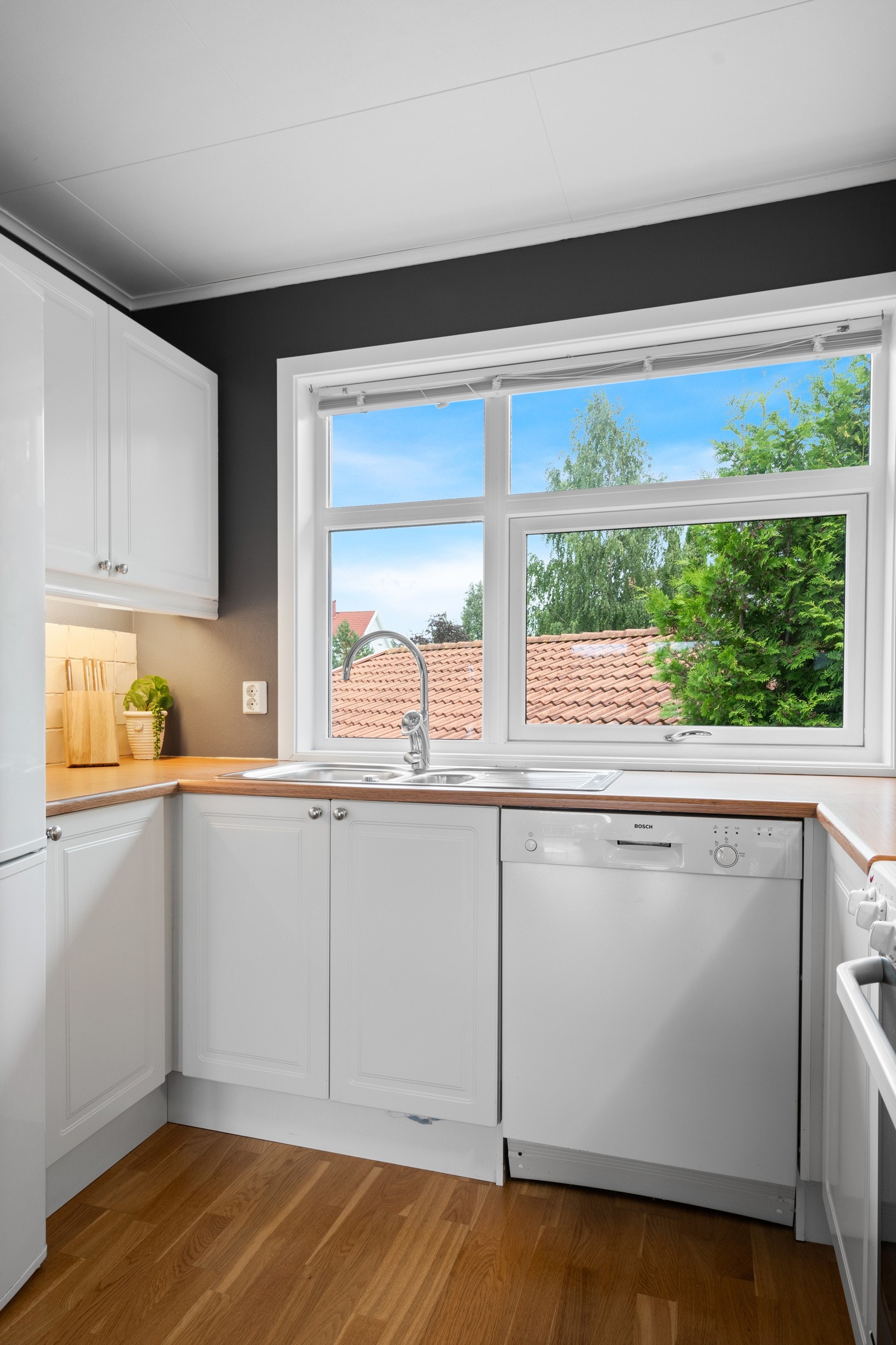 Kjøkkeninnredningen har profilerte hvite fronter, og det er gode arbeidsflater på en laminat benkeplate. Galleribilde