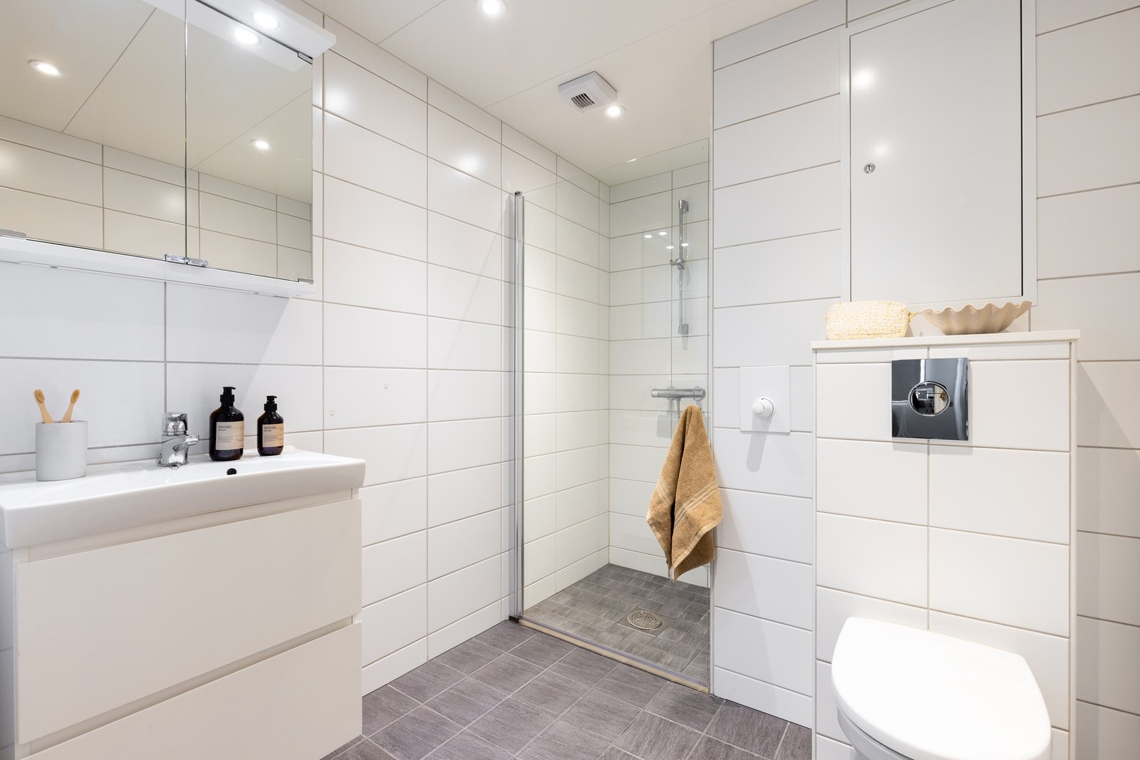 En-suite bad fra hovedsoverom. Her er det gulvvarme, downlights i tak, skuffeløsning og speilskap. Galleribilde
