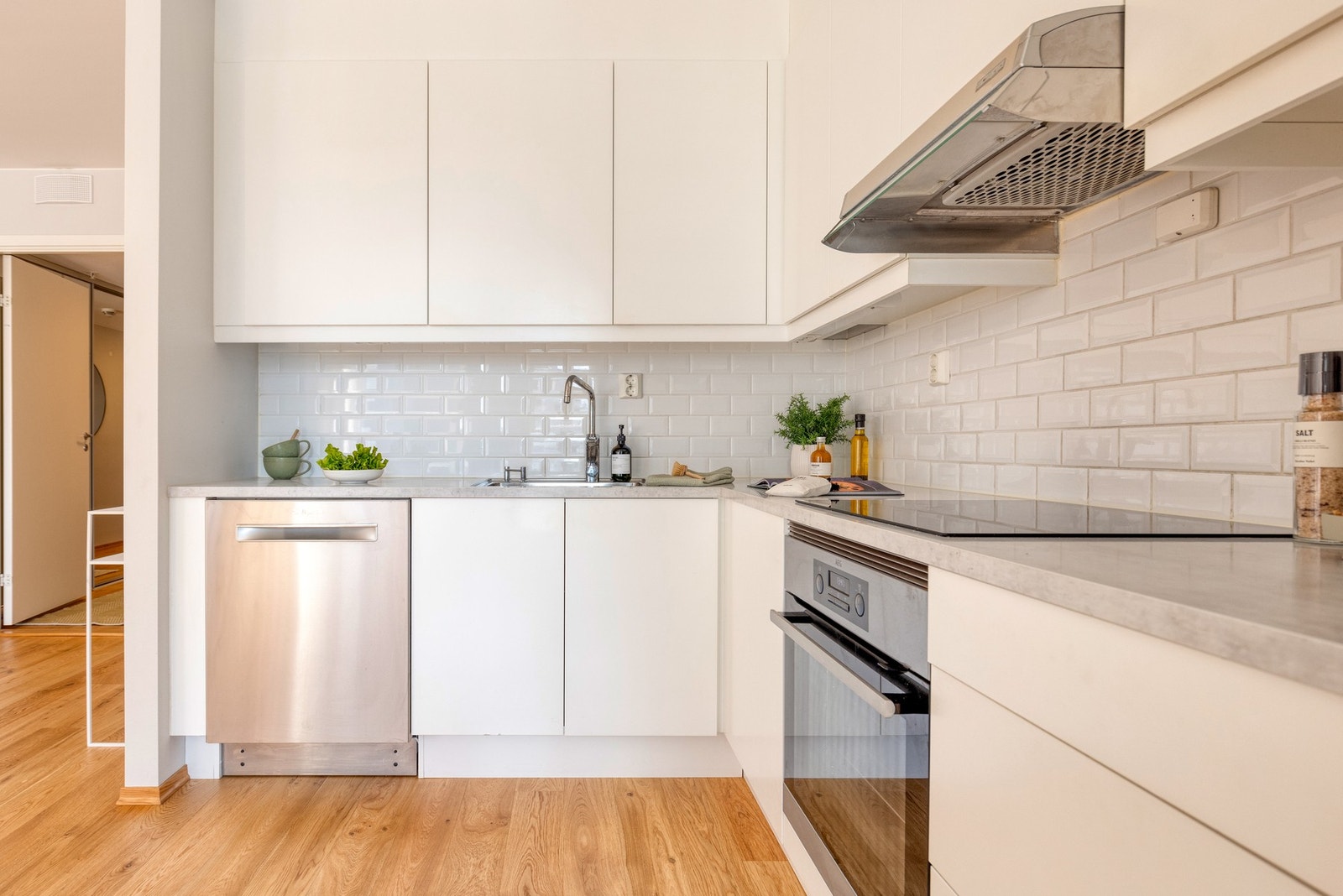 Mellom benkeplaten og overskap er det lekre, hvite splashback-fliser for enkelt vedlikehold og et helhetlig uttrykk. Galleribilde