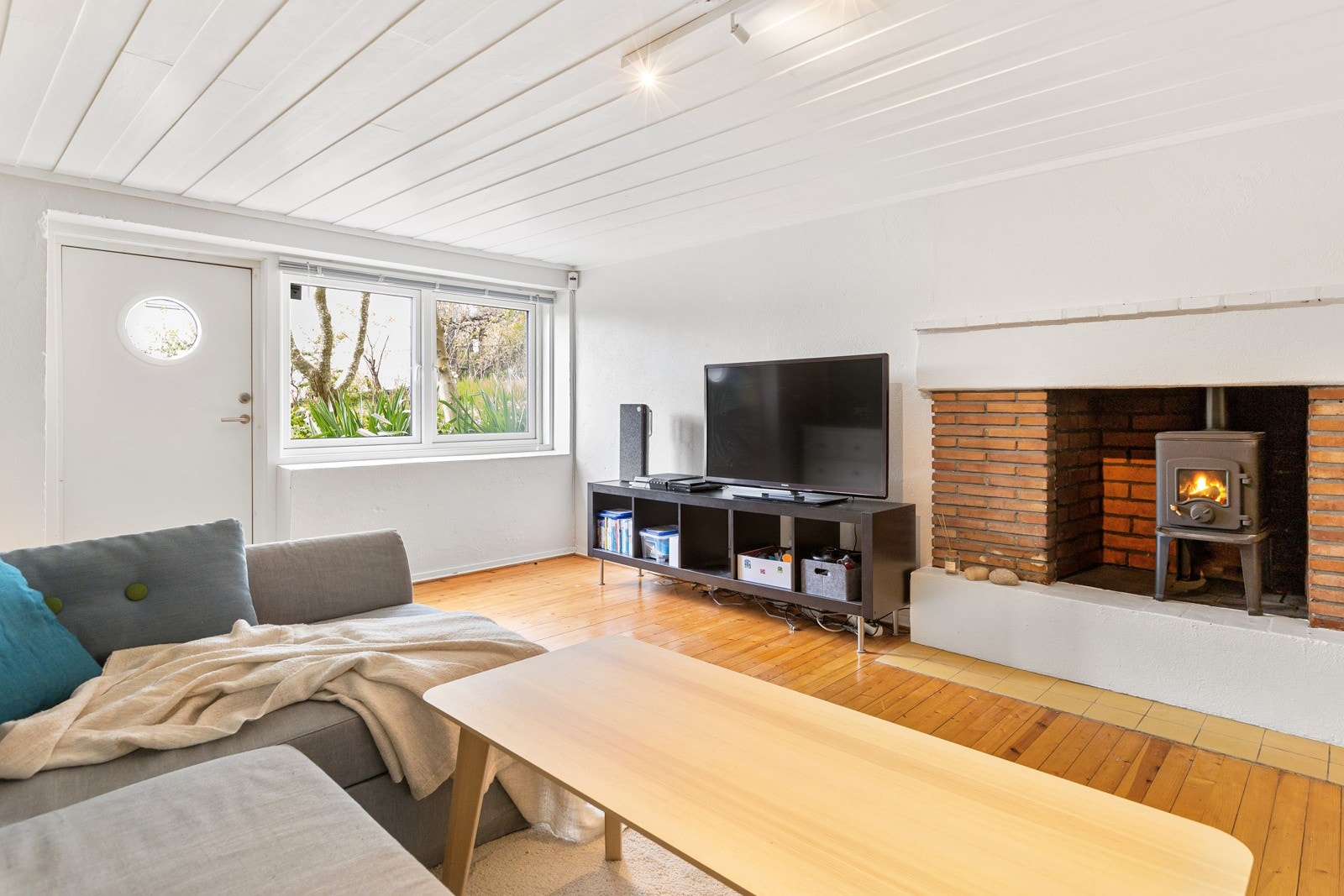 Lys og luftig kjellerstue med originalt gulvbord og malte overflater. Her er det god plass til både sofaseksjon og øvrig møblement. Videre i kjellerstuen er det peis og egen utgang. Galleribilde