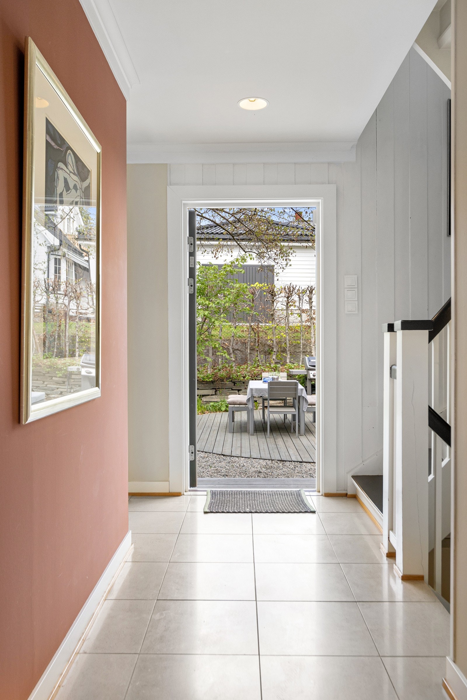 Stor entré med lyse fliser på gulv og malte overflater i moderne fargevalg. Galleribilde