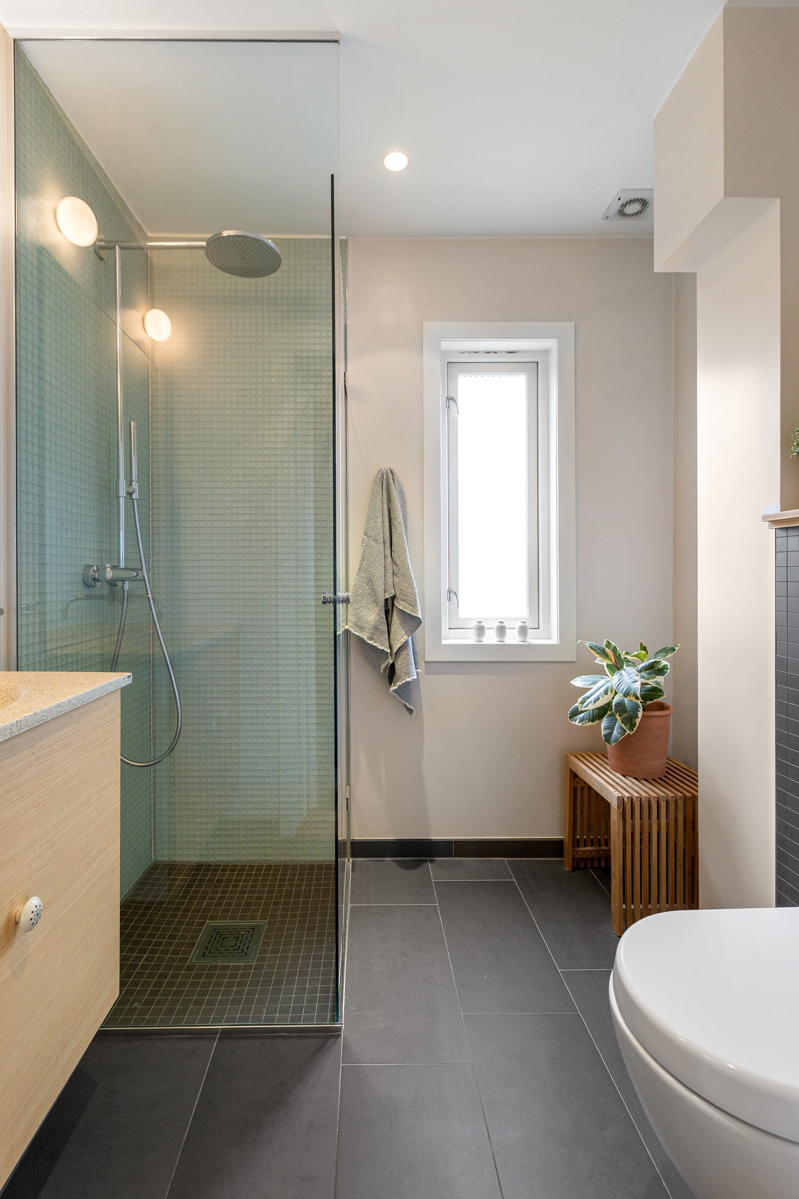 Badet i 1. etasje ble pusset opp i 2012, og har mørke fliser på gulv med varme, lyse overflater og i dusjen er det fliser i glassmosaikk. Galleribilde