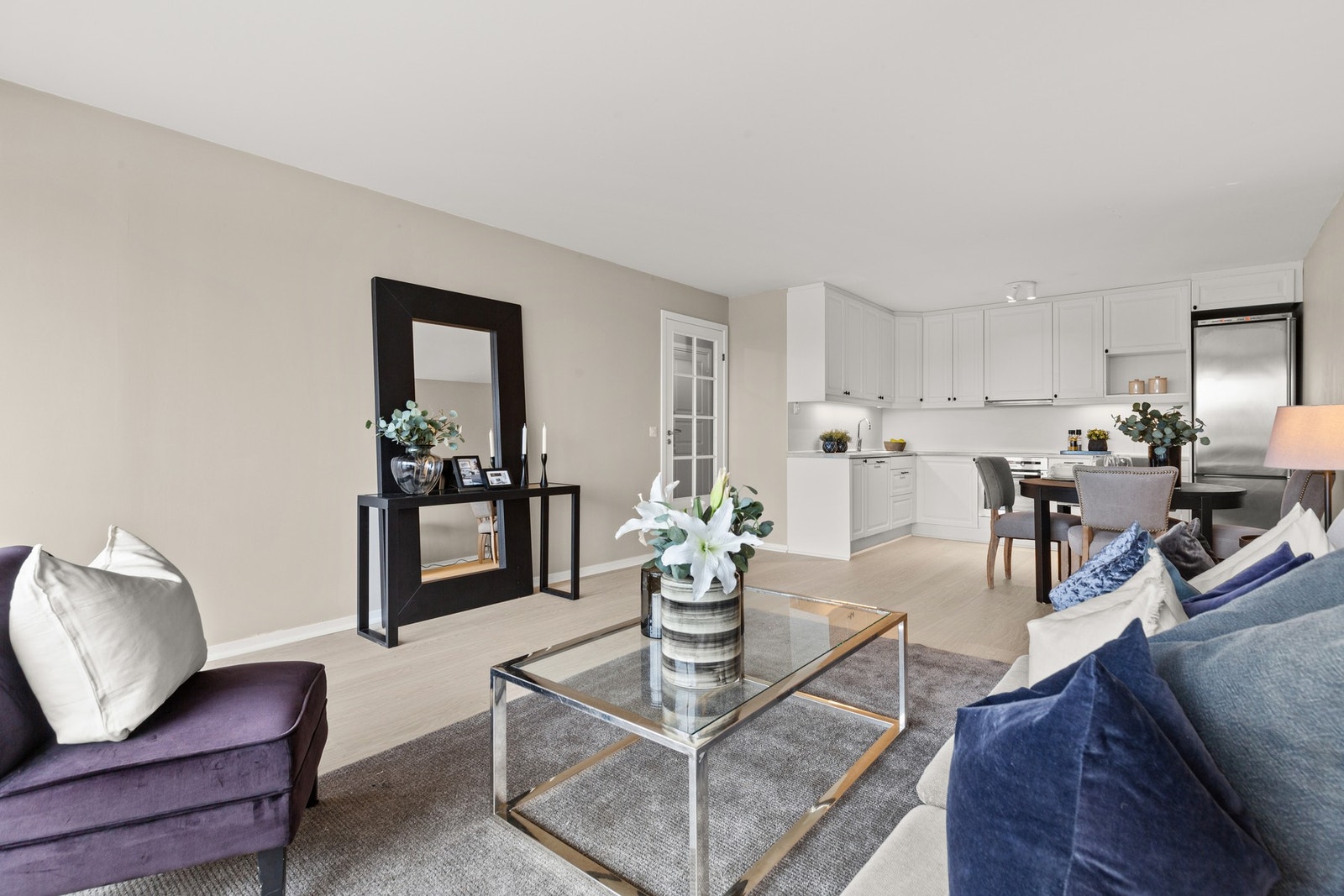 Romslig lys stue med pen glassdør mot entré Galleribilde