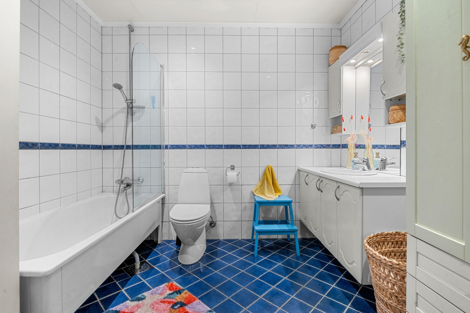 Romslig, flislagt bad på ca 6m2, badekar med dusjvegg, og god oppbevaringsplass i baderomsskap. Galleribilde