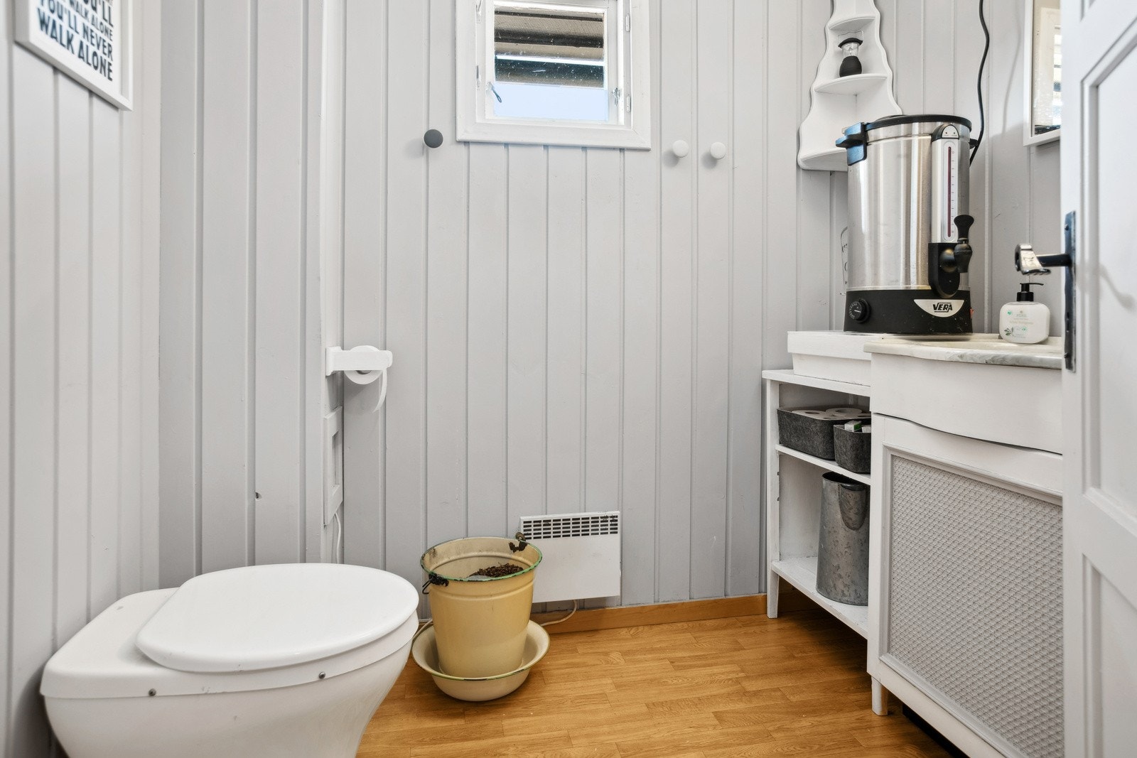 Rommet har vegghengt servantskap med servant, speil med belysning og gulvmontert snurredass. Galleribilde