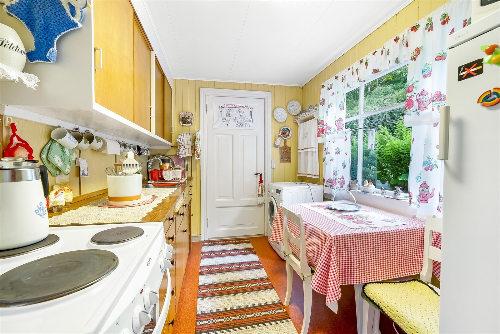 Koselig kjøkken i bakre del av boligen med vindu og dør ut mot bakhagen. Galleribilde