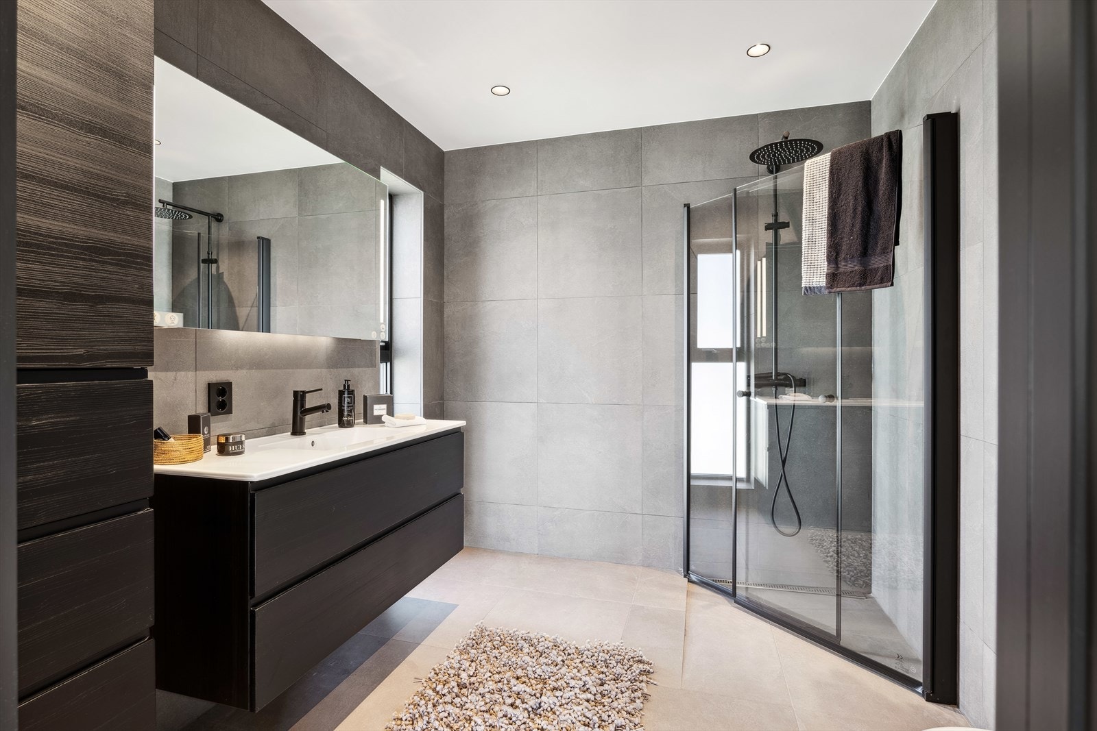 Badet inneholder dusjnisje med takdusj, vegghengt wc, skap med innredning og speil. Galleribilde