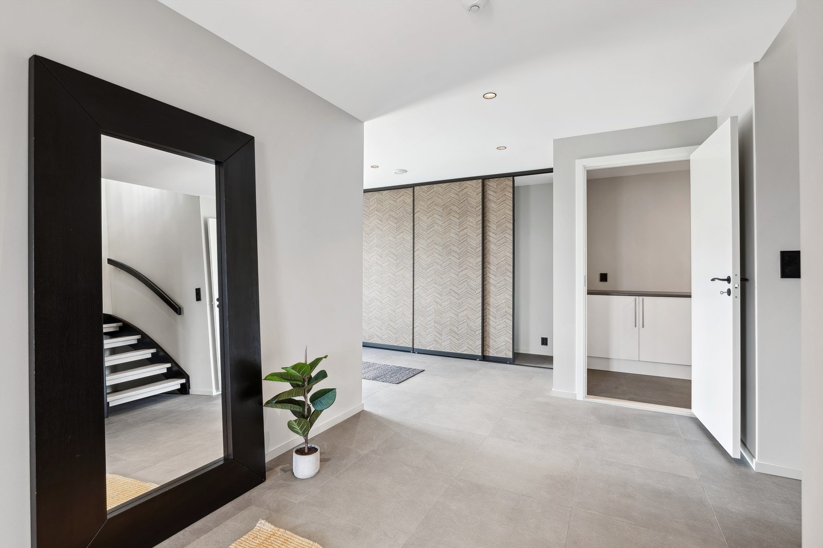 Hallen har en stor langsgående skyvedørsgarderobe og spotlights i tak. Galleribilde