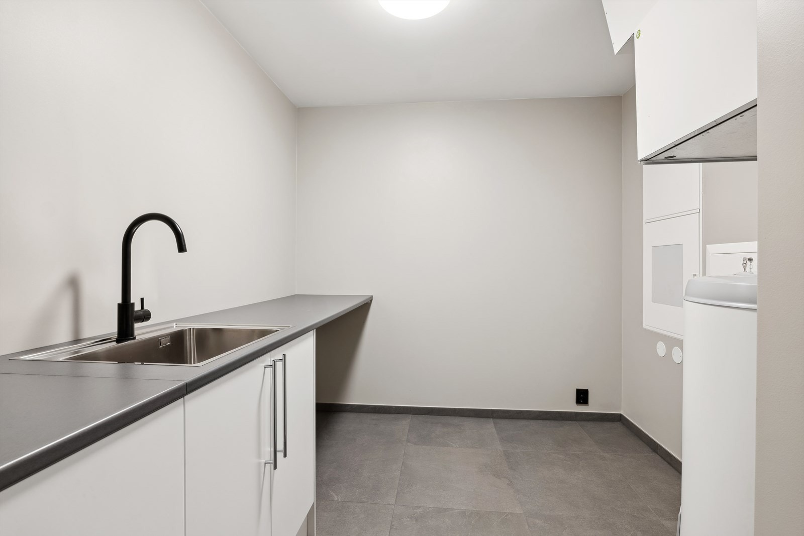Det er eget vaskerom/teknisk rom med plass til vaskemaskin og tørketrommel i skapinnredning med vask. Galleribilde